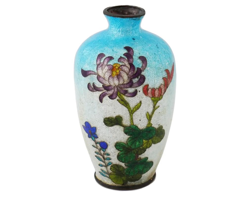 An antique Japanese, late Meiji era, Ginbari enamel over copper vase. The urn shaped vase is enameled with a polychrome image of blossoming flowers on the light blue ground made in the Ginbari Cloisonne technique. Ginbari is a Japanese cloisonne