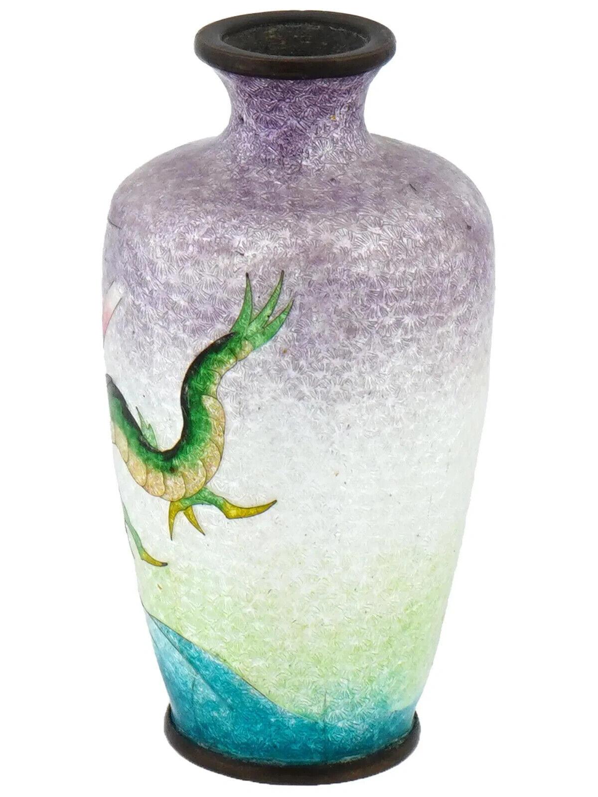 Antiguo jarrón japonés, de finales de la era Meiji, de esmalte Ginbari sobre cobre. El jarrón en forma de urna está esmaltado con una imagen policromada de un dragón volando sobre las olas sobre fondo azul claro, realizada con la técnica del