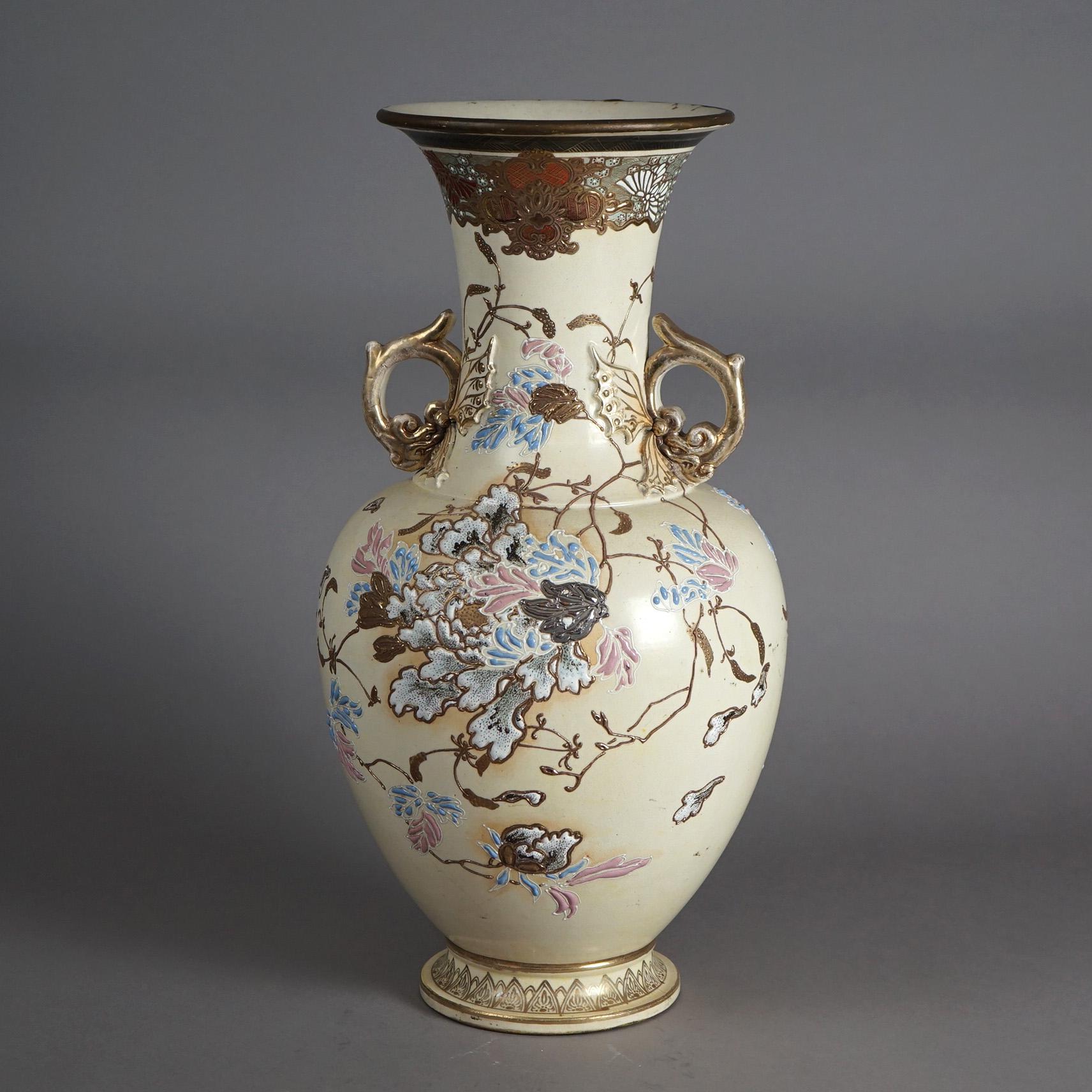 An antique Japanese Meiji vase offers pottery construction  with hand painted floral garden design, double handles and gilt highlights throughout, signed on base as photographed, c1900

Measures- 20.5''H x 10.5''W x 10.5''D