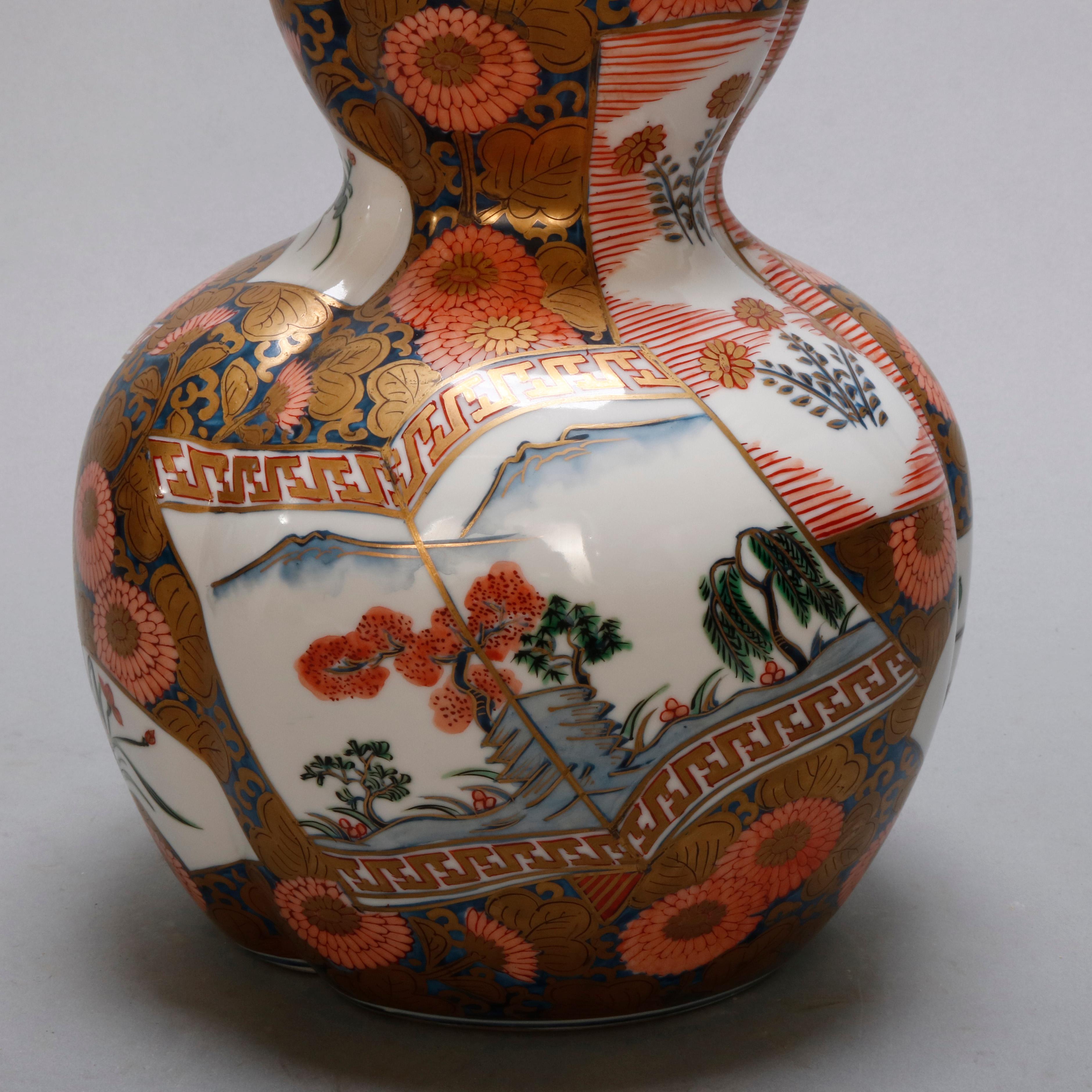 An antique Meiji Imari vase offers porcelain construction in gourd form hand painted with overall figured pattern with stylized floral elements and reserves depicting landscape scenes, signed on base as photographed, circa 1900.

Measures - 14.75