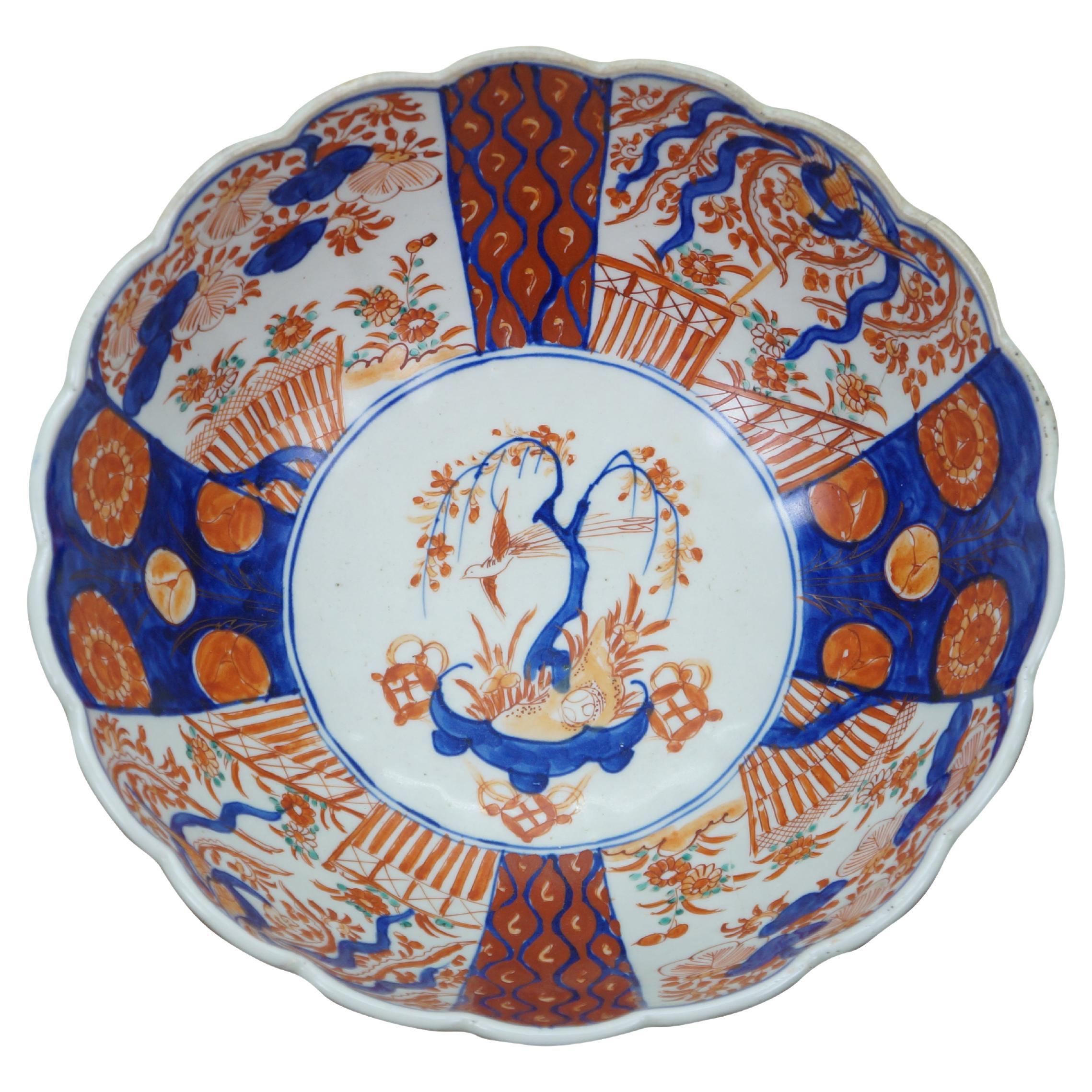 Antique Japanese imari porcelain fruit / serving bowl - round form with scalloped edge, decorated in blue and orange with alternating panels of blossoms and phoenix flying over gardens of flowers, and a bonsai tree in a pot at the