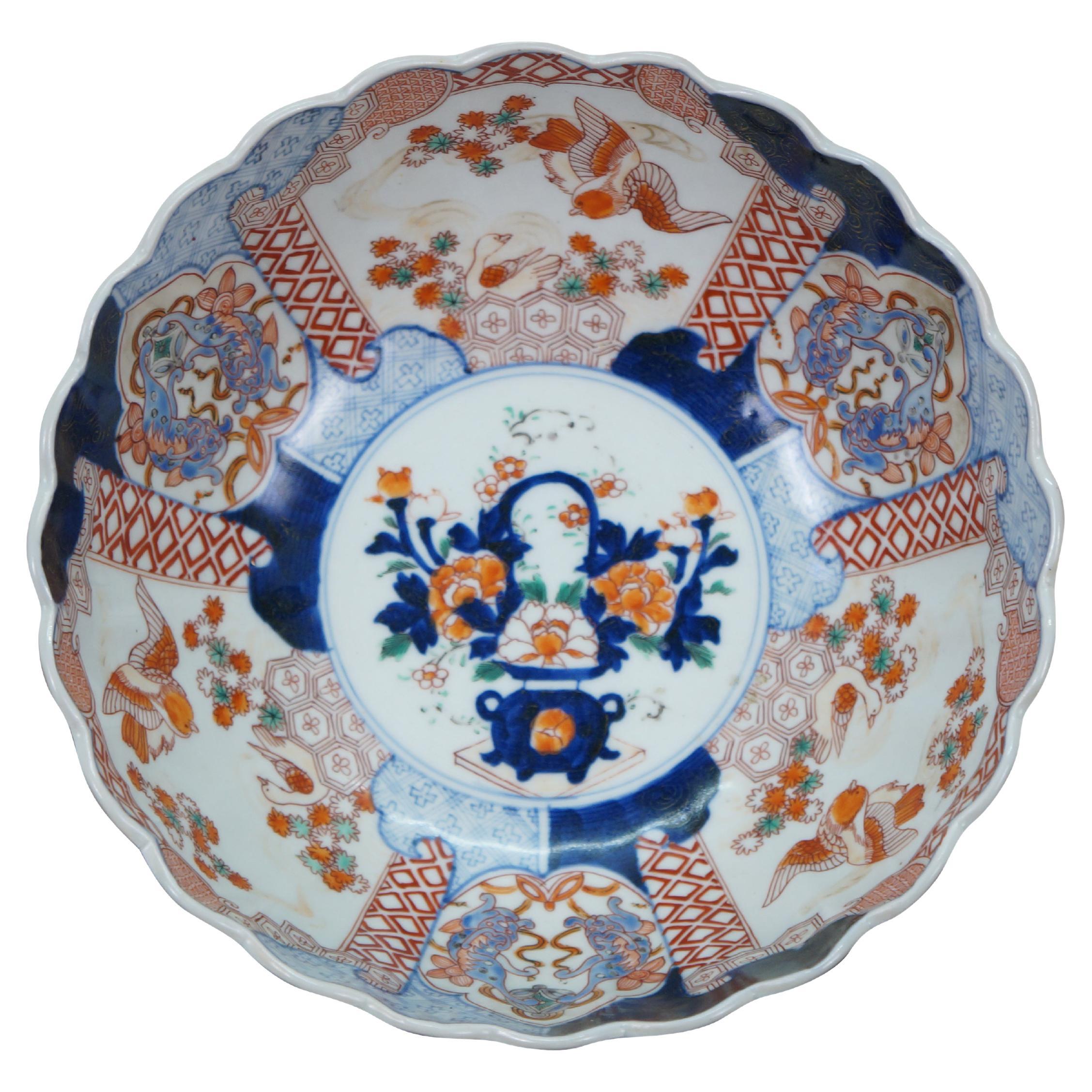 Antique Japanese imari porcelain fruit / serving bowl - round form with scalloped edge, decorated in blue, orange and green with Mandarin ducks nesting in a garden, pairs of blue guardian lions, and a bouquet of flowers in a vase at the