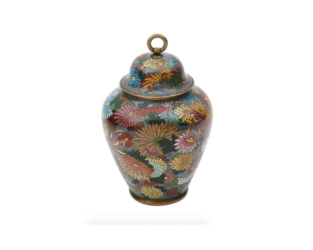 An antique Japanese Meiji period cloisonne covered jar adorned with exquisite floral designs. This cloisonne jar showcases the mastery of Japanese artisans in the intricate technique of cloisonne enamel work. The jar features a vibrant color palette