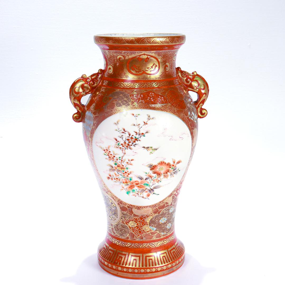 A fine antique Japanese Meiji period Kutani porcelain vase.

By Matsumoto Sahei/Shoundo.

In an aka-e style decorated throughout in iron red with extensive gilt accents.

There are cartouches to either side both with branches of red flower with a