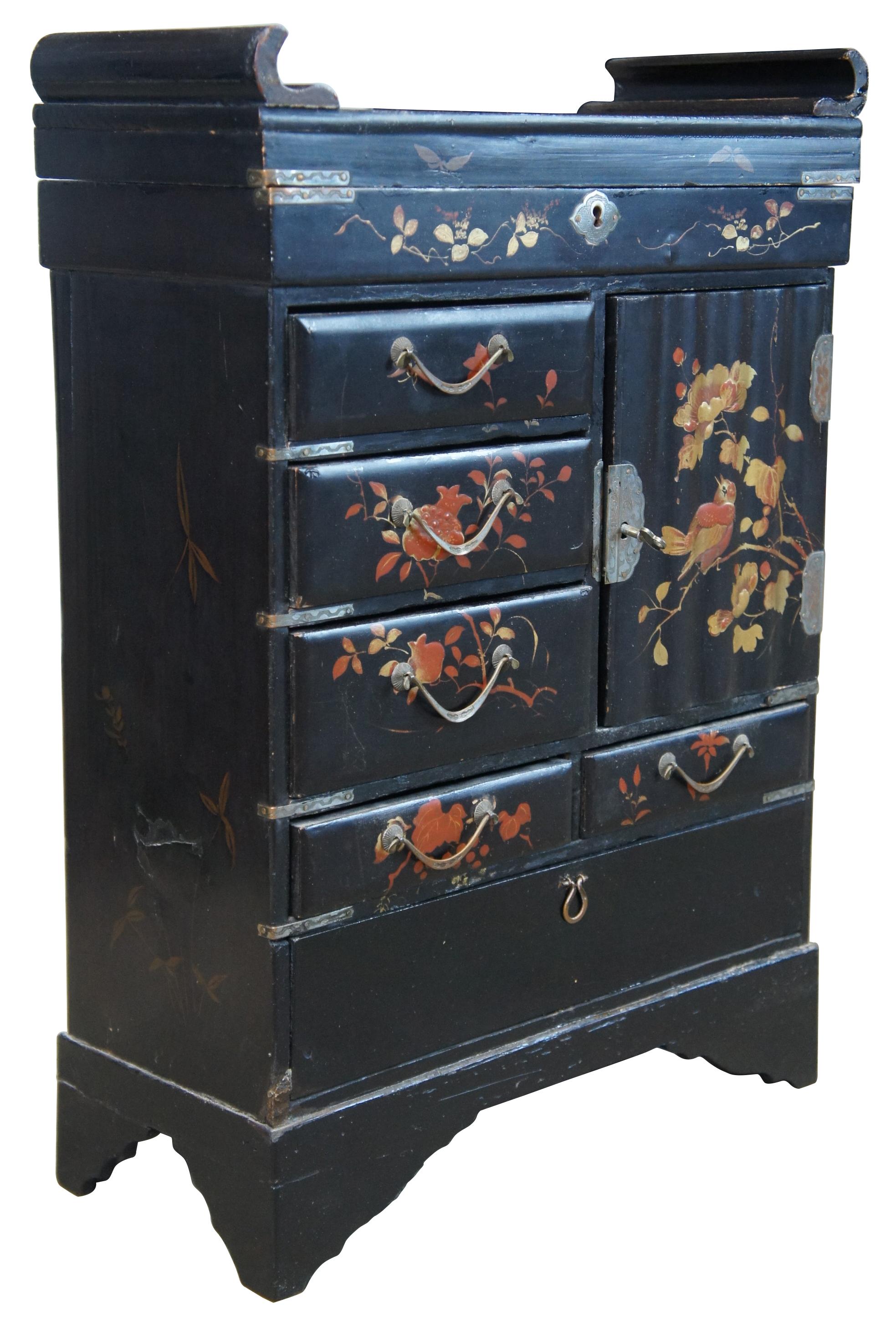 Antique Japanese Meiji Period vanity box in the form of a miniature armoire / chifferobe or Tallboy dresser, circa late 19th century. A rectangular form made from wood with black lacquer finish. Hand painted in red and gold featuring a foliate and
