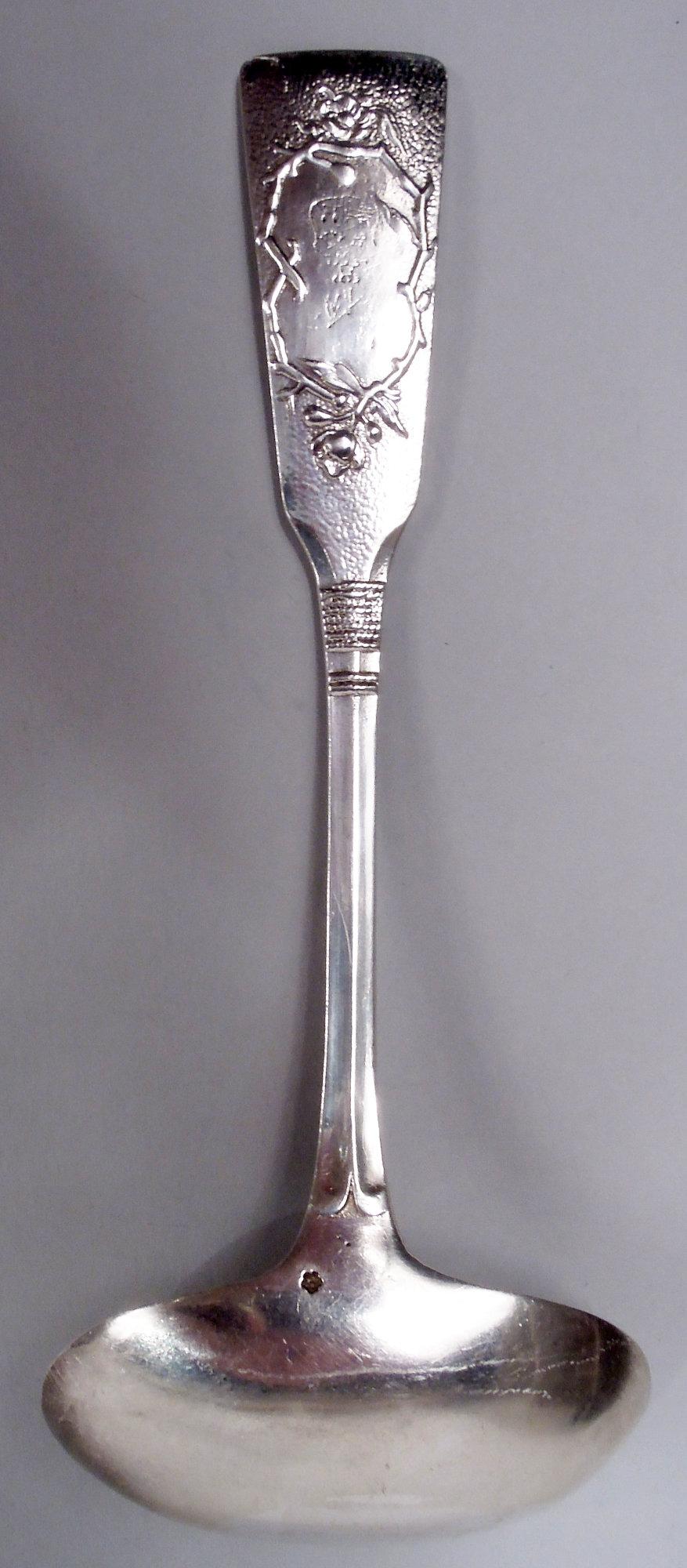 Mestolo per salse in argento giapponese Meiji, 1910 circa. Terminale rettilineo fuso e stippato. Sul recto, ramo di pruno in fiore a basso rilievo; sul verso, incisione usurata in una cornice di ramo in fiore. Gambo 