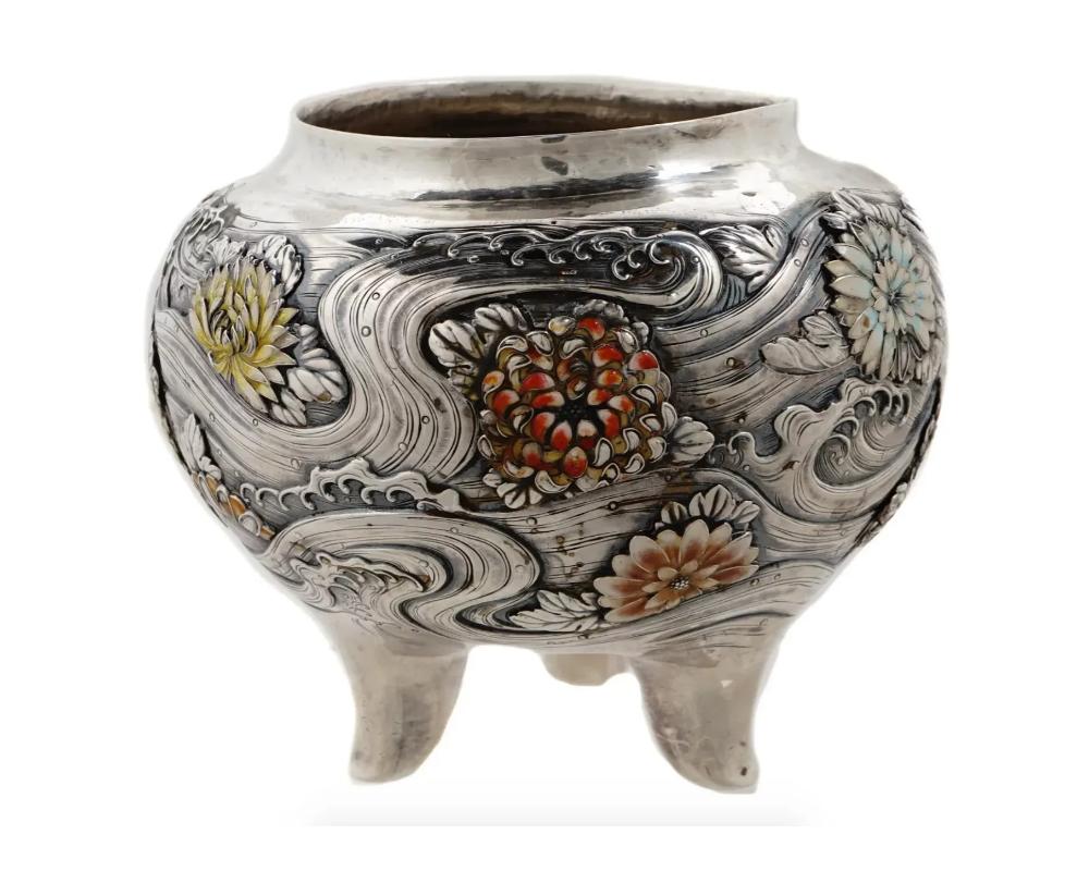 Antique Japanese Meiji period solid silver bowl chased with floral designs and adorned with enamel decorations. Stands on three feet. Signed to the bottom with engravings. Circa the early 20th century. Antique Japanese Silver Bowl