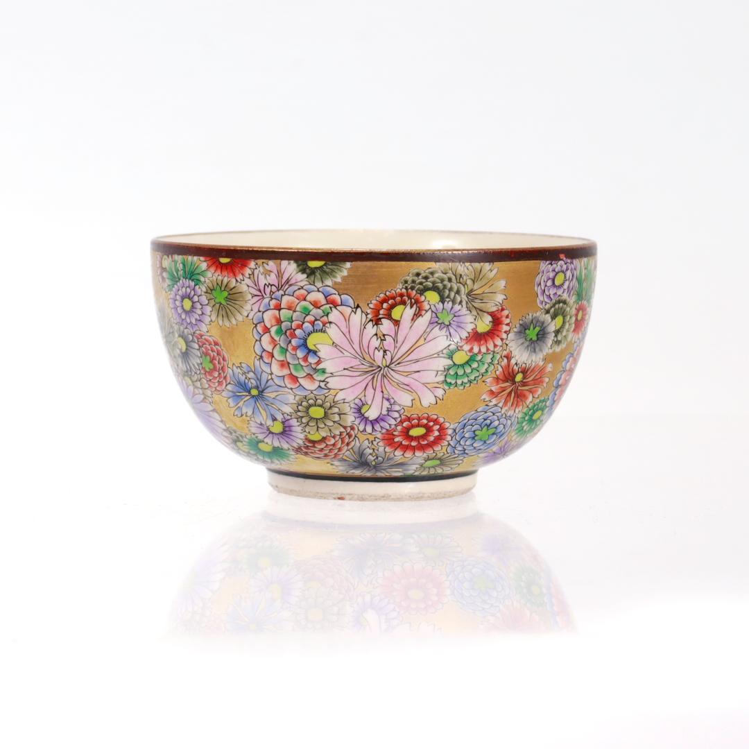 A fine antique Satsuma ware porcelain teacup or chawan.

By Shuzan.

With a cream ground and an entirely gilt exterior covered with extensive floral decoration of various flowers in reds, blues, greens, yellows, and pinks. 

The rim is gilt and has