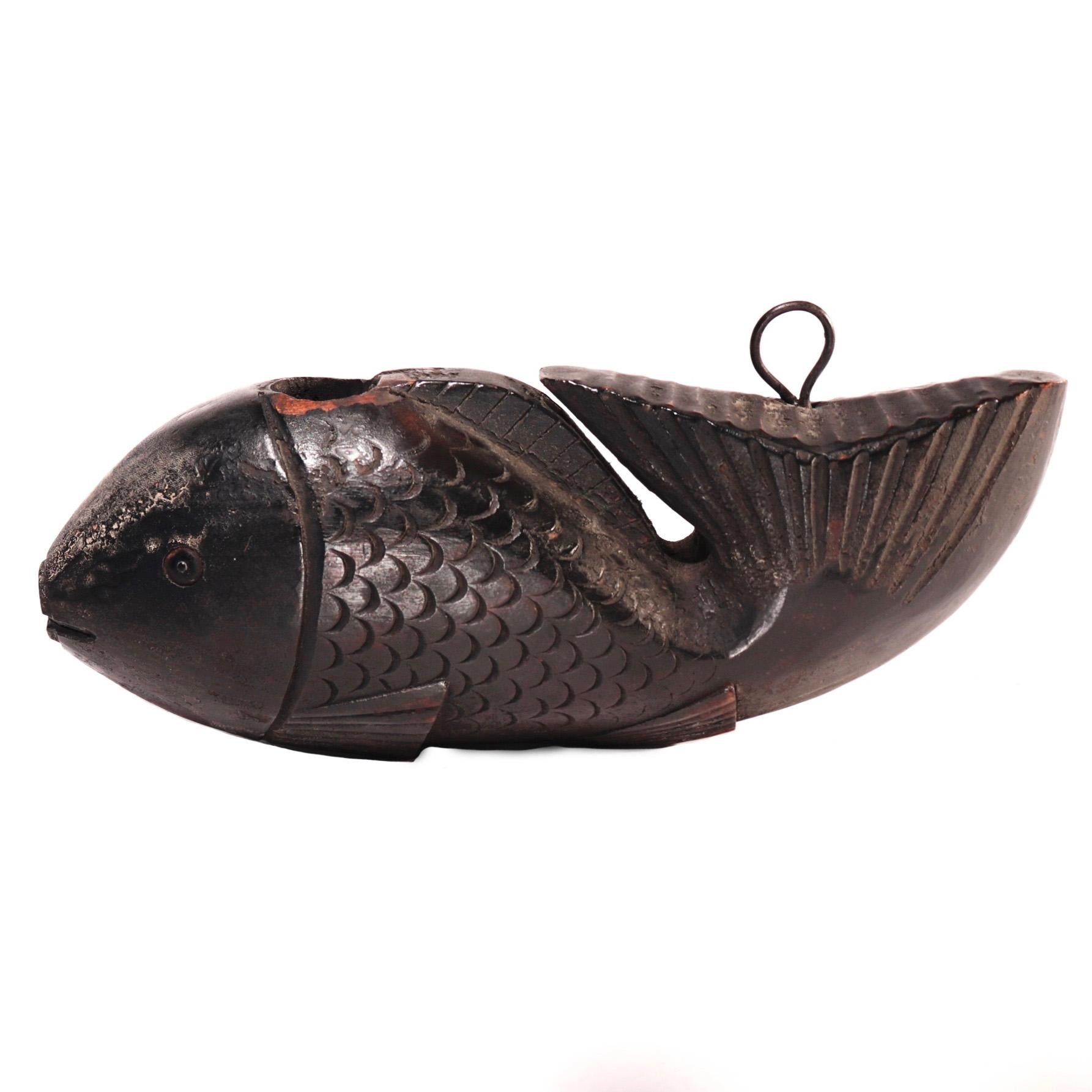 Antique Japanese Yokogi, a fish shaped fulcrum for the pot hook assembly over the hearth, a naively carved Tai (Sea Bream) with large head pierced for the hooked pole and the large tail pointed upward with a metal loop for the cord attachment,