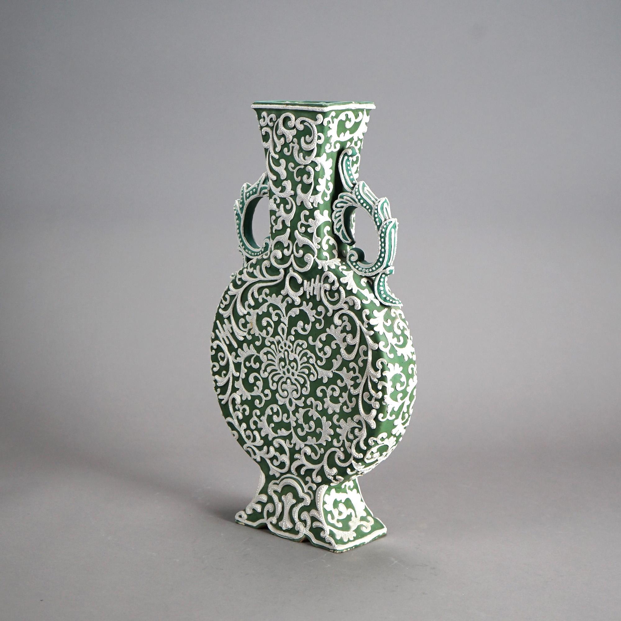 An antique Japanese pillow vase offers pottery construction with green glaze, scroll and foliate moriage elements in relief and double foliate form handles, c1920

Measures- 18.25''H x 10.25''W x 3.5''D