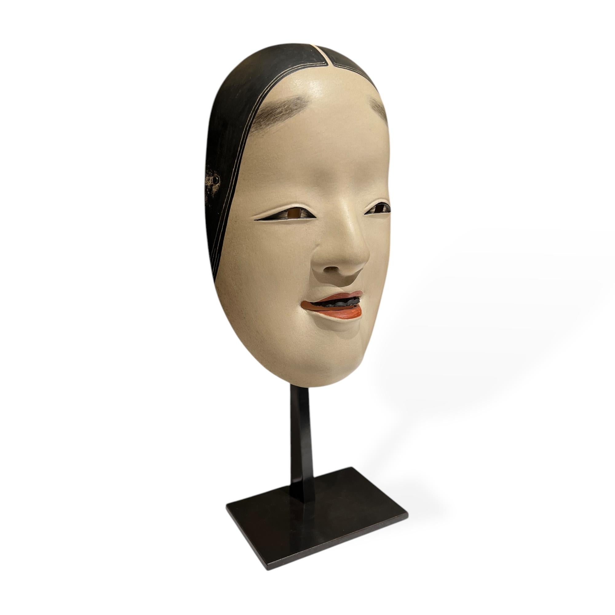 Masque de théâtre nô représentant Ko-Omote, Japon, XIXe siècle.

Ce masque est un Ko-omote, l'un des masques les plus anciens et les plus emblématiques du théâtre nô. Sculptée dans du bois de cyprès japonais, elle représente une jeune femme au