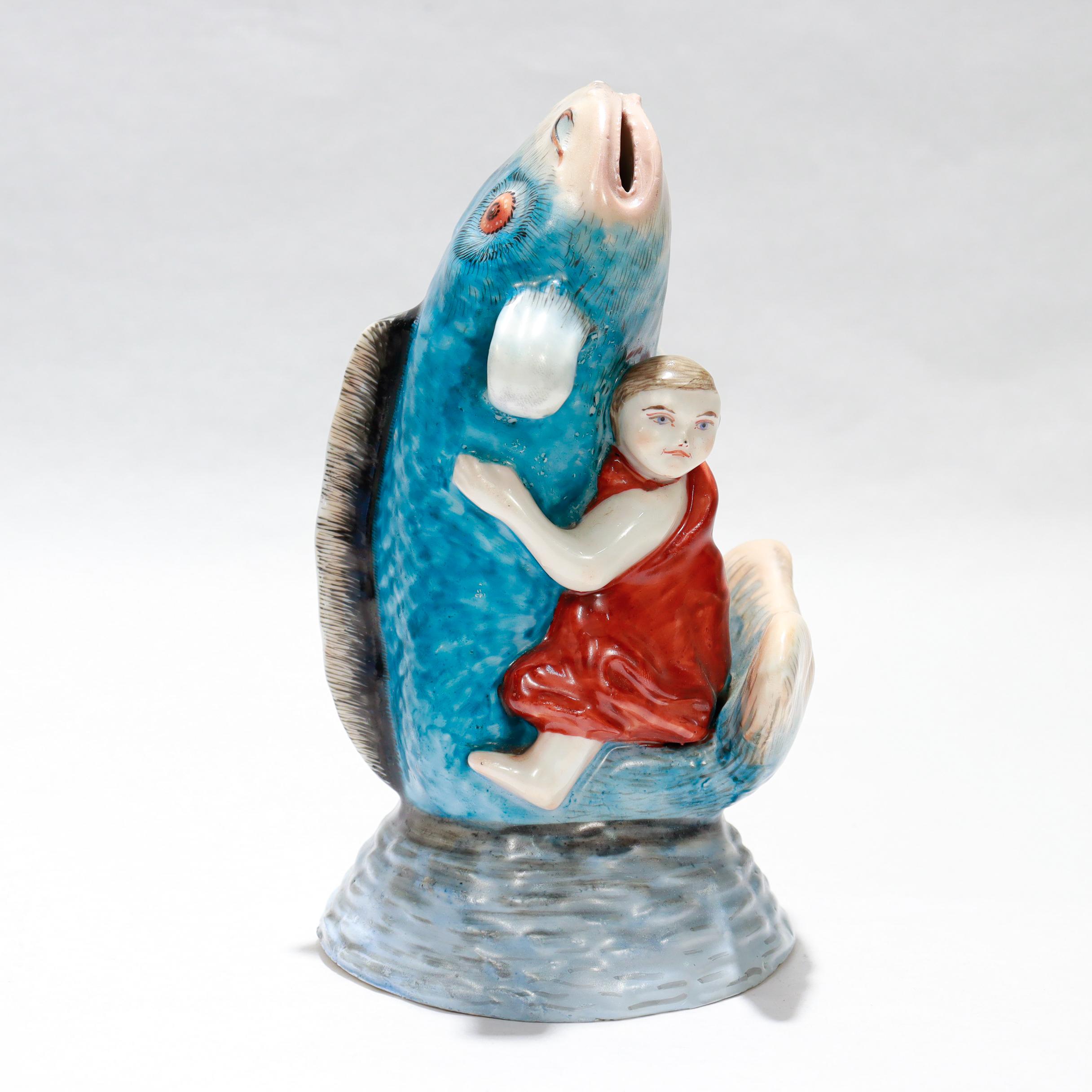 Une belle figurine en porcelaine japonaise vintage ou okimono.

Représentant Kintaro (金太郎) luttant contre un poisson-chat géant ou poisson koi. 

Kintaro (connu plus tard sous le nom de Sakata no Kintoki) est un héros folklorique japonais plus grand