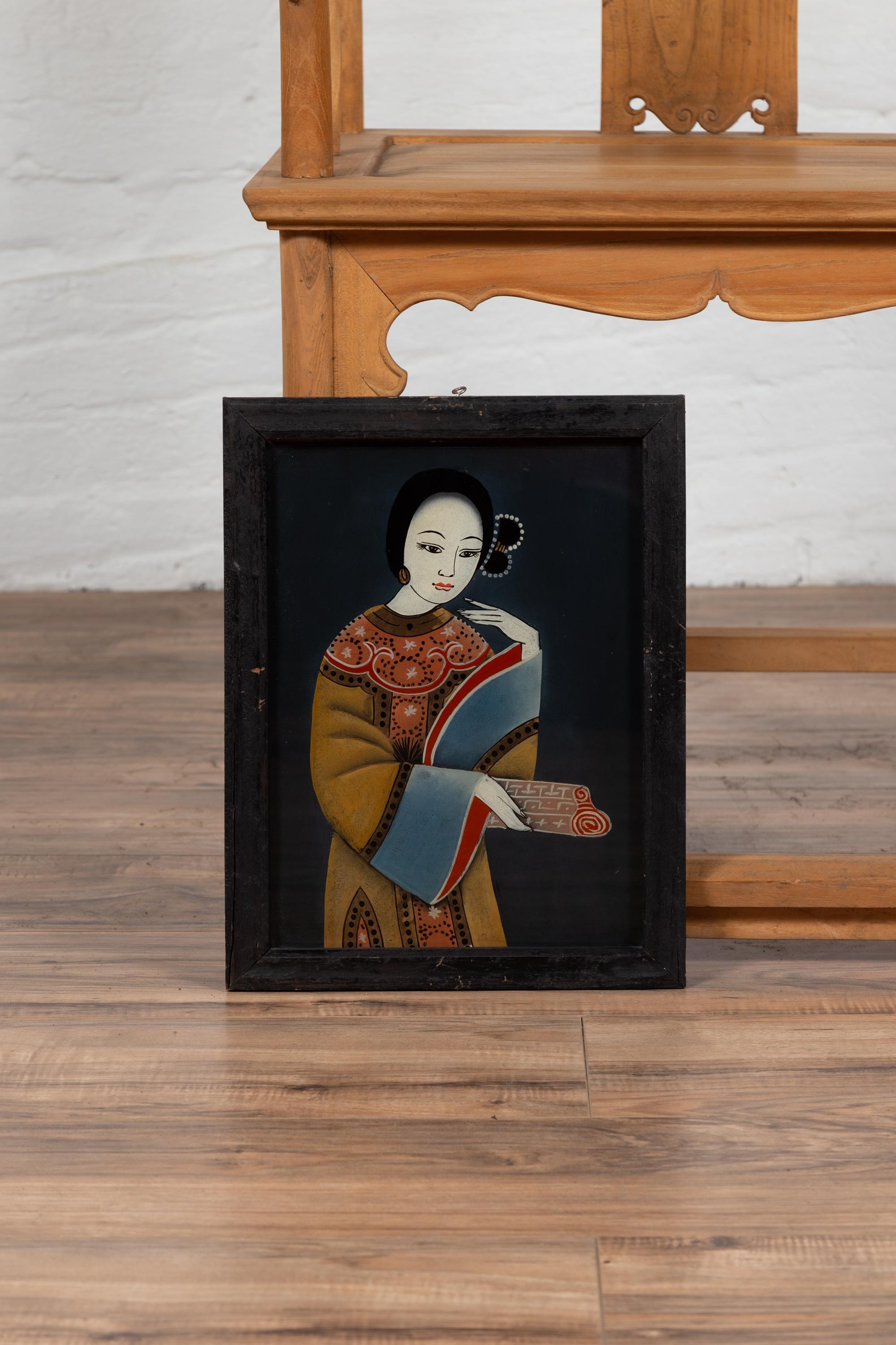 An antique framed Japanese painting on glass from the early 20th century depicting a woman. Born in Japan during the early years of the 20th century, this exquisite painting on glass depicts an elegant woman, dressed with a lovely mustard, blue