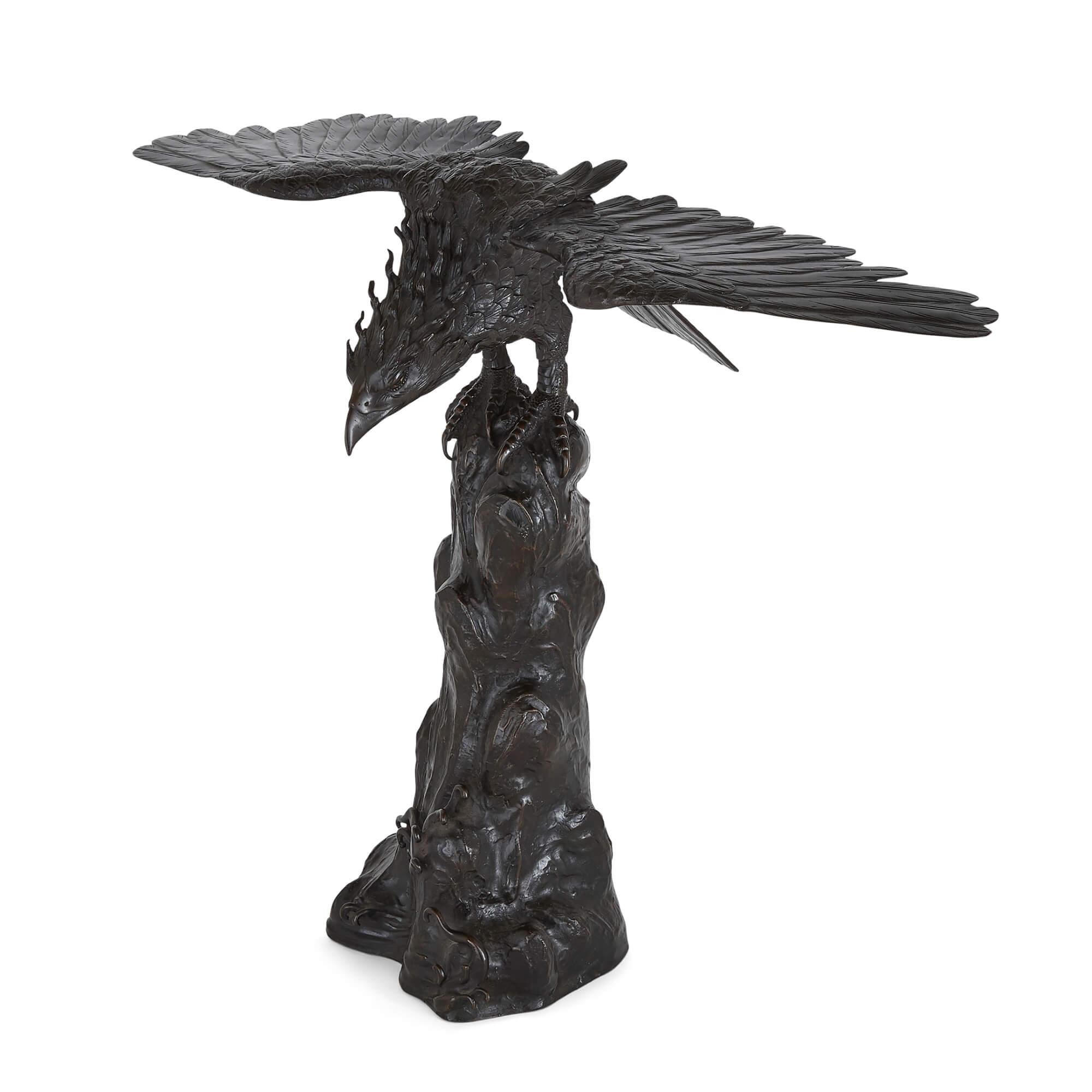 Antique Japanese patinated bronze eagle
Japanese, c. 1900
Height 54cm, width 67cm, depth 32cm

This fine and naturalistic Meiji period bronze model is cast into the form of an eagle, who grips into his stump-like perch with long claws as his wings