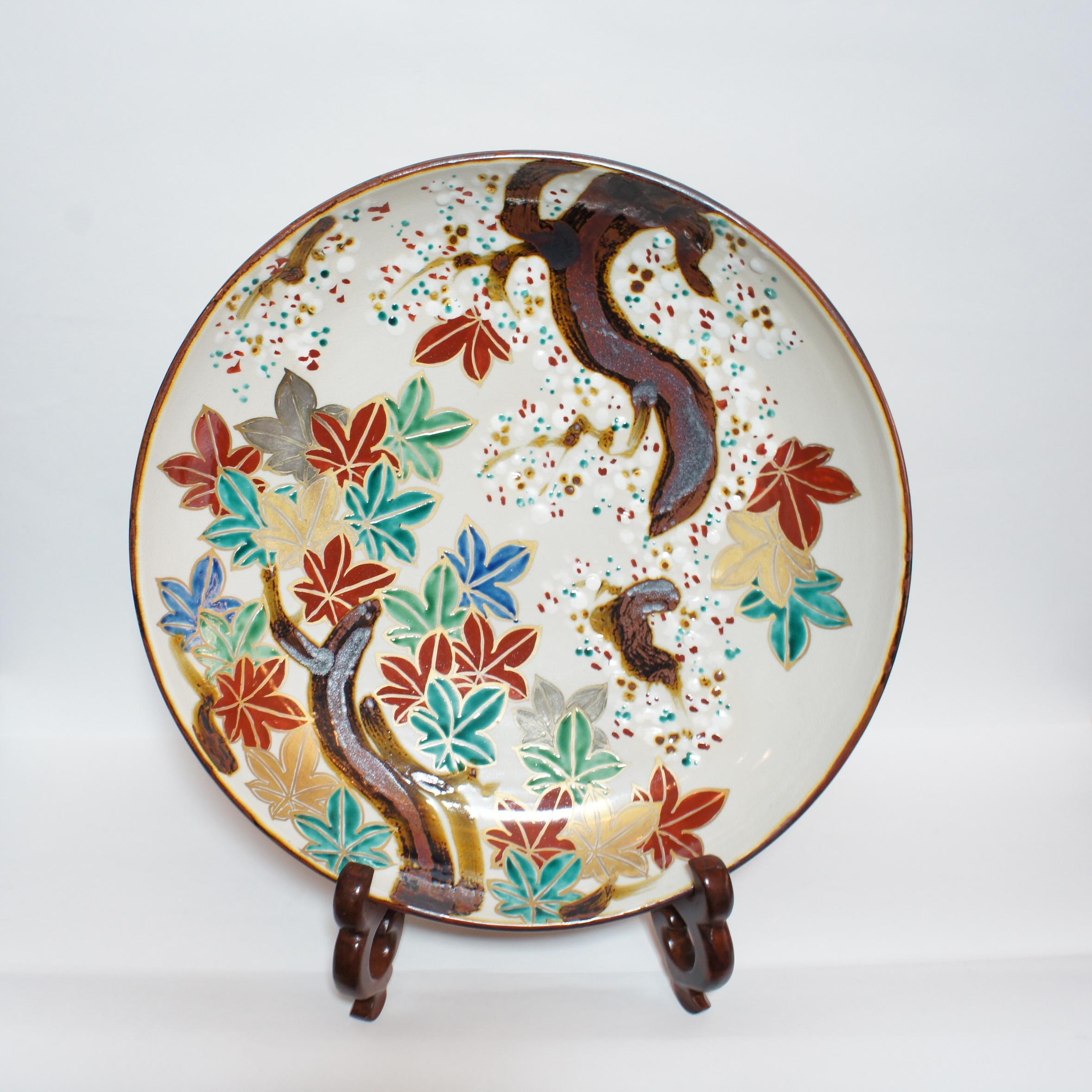 This plate was made with porcelain, style of Inuyama-yaki and made around 1960s. The dimensions are 36×36×H8 cm. 
A boldly drawn pattern of autumn leaves and cherry blossoms, two patterns emblematic of Inuyama Ware are highlighted on this delicate