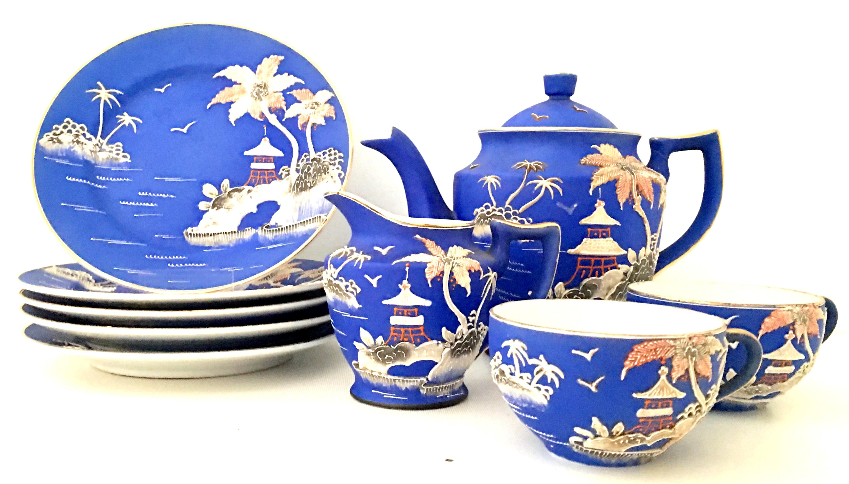 Antique Japanese Porcelain Hand Painted Moriage Coffee-Dessert ,Ten Piece Set. This rare palm tree and pagoda motif, features a vibrant blue ground with orange, white, black and 22-karat gold detail. Set includes five plates, two tea cups, one