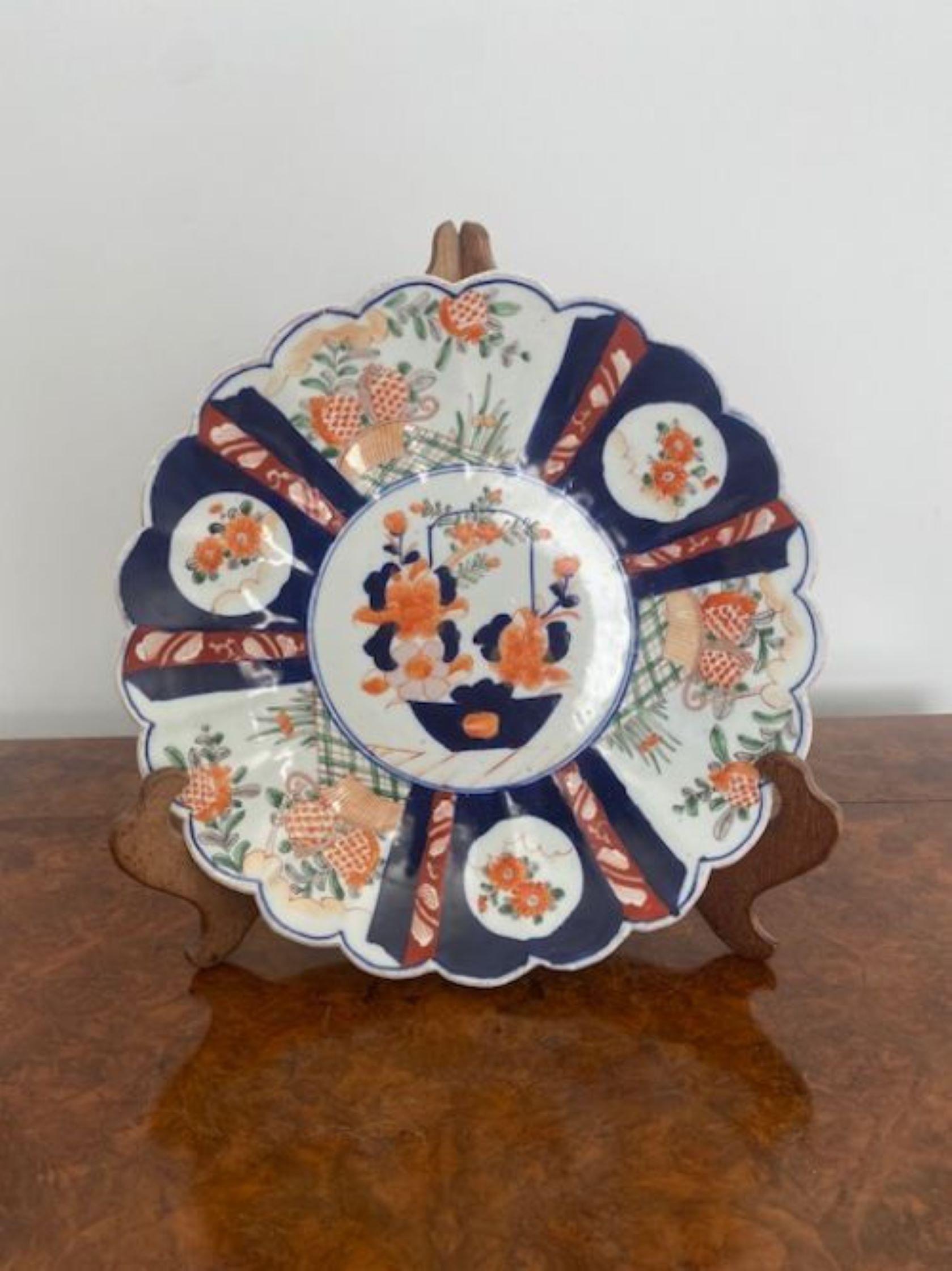 Antique Japanese quality Imari plate having a quality scalloped edge with wonderful hand painted decoration with flowers, leaves and a basket of flowers to the centre in red, green, orange, blue and white colours