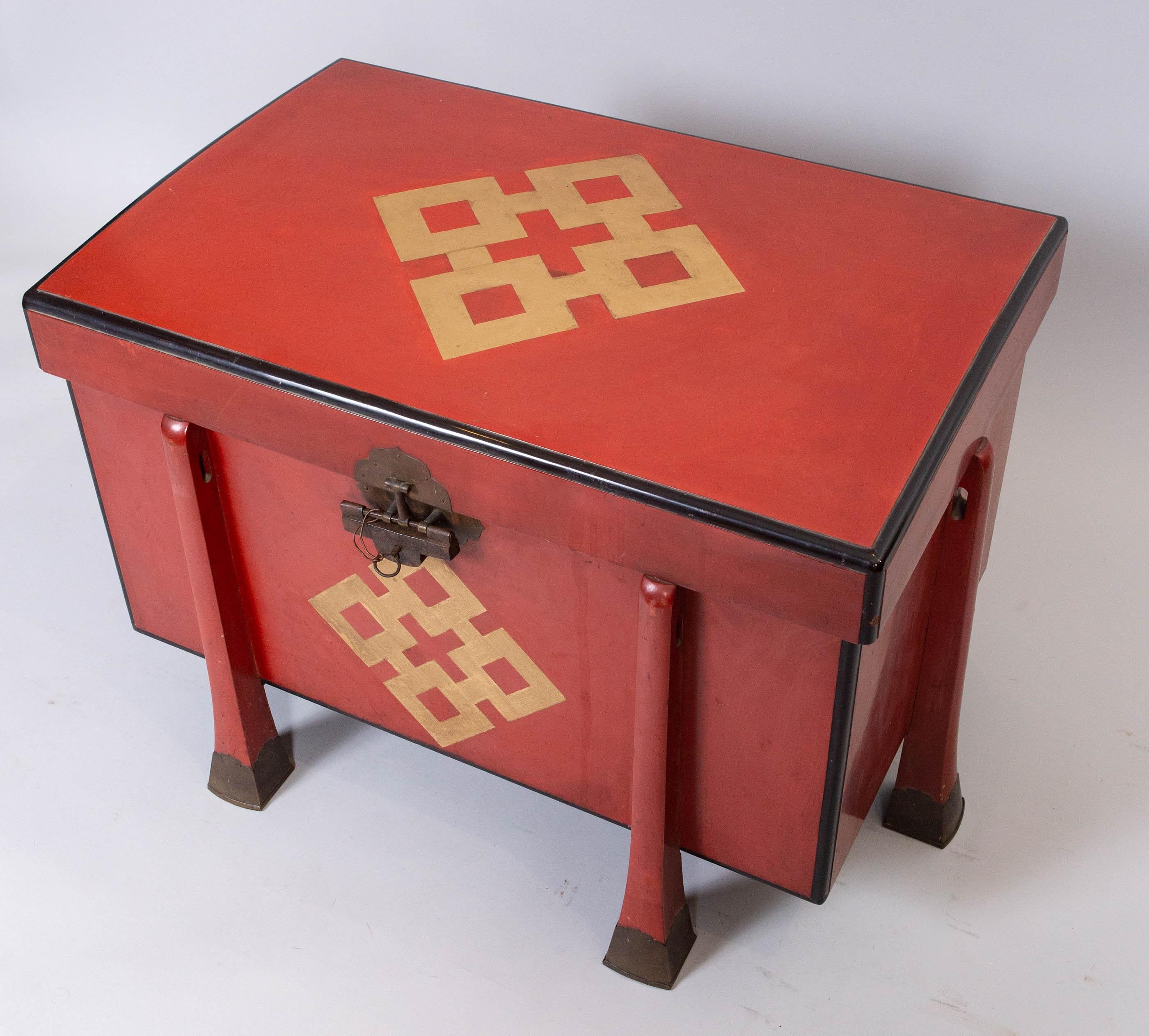 6-legged armor box made of red lacquer with crest design in gold, and bronze mounted feet. Comes with original lock and key.