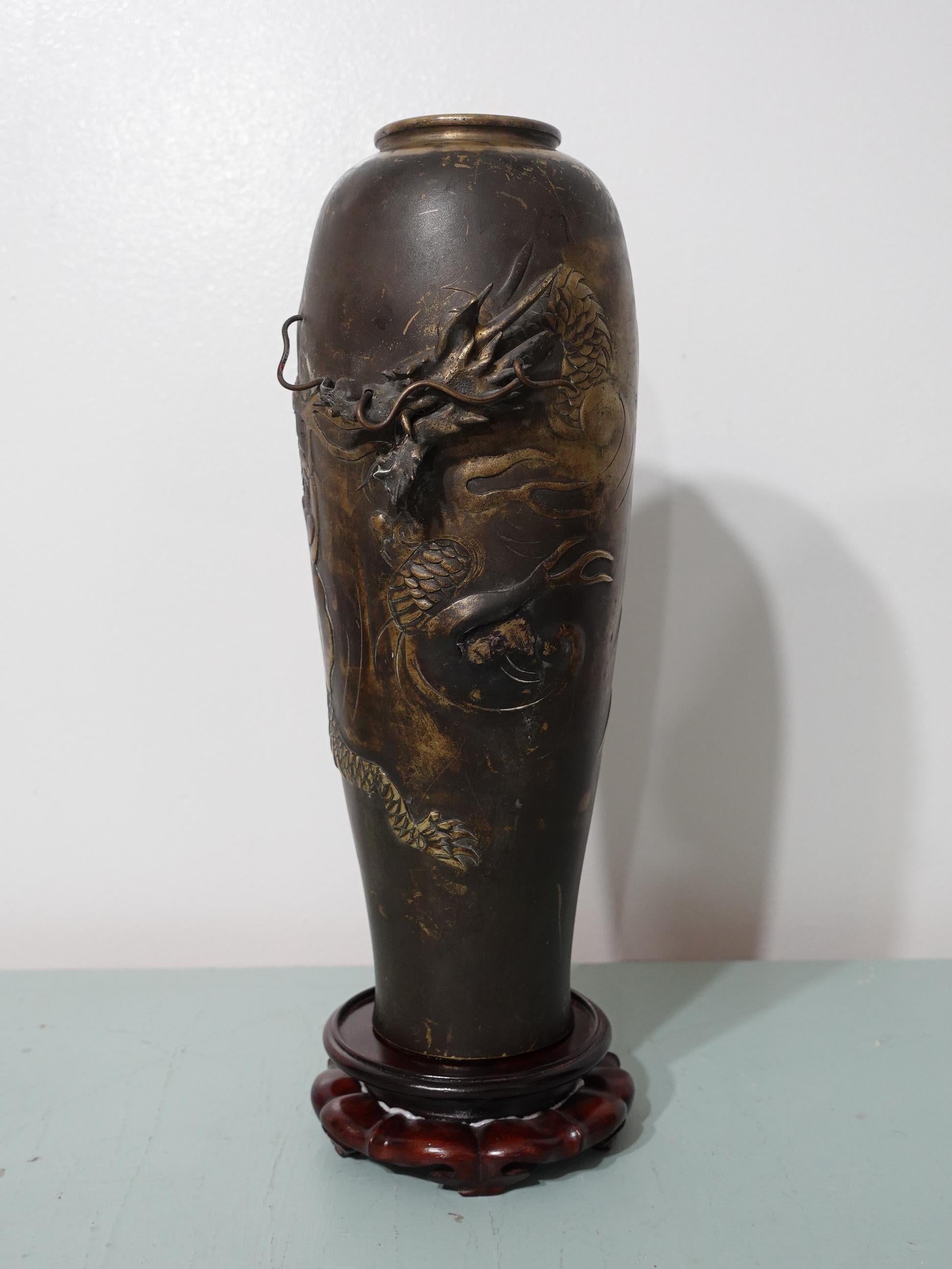 Un beau vase antique japonais en bronze sculpté en relief avec un support en bois dur.
Une tête de dragon en relief complexe, fabriquée à la main, avec des antennes de dragon qui entrent et sortent du corps du vase.
Je pense que le vase a été