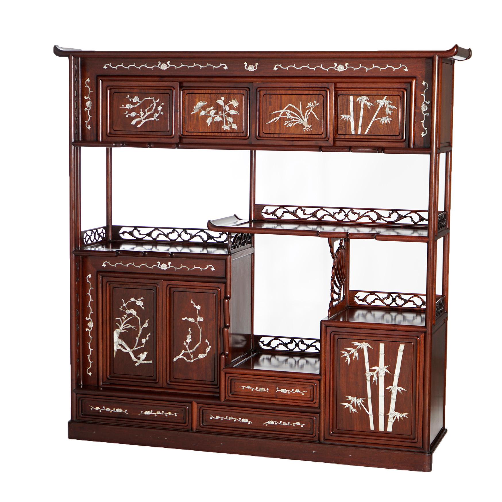 An antique Japanese tansu offers rosewood and mahogany construction with folate carved rails and fans, inlaid mother of pearl bamboo and foliate design, cabinets and offset shelving units, c1920

Measures- 58''H x 58.5''W x 14.5''D.

Catalogue Note: