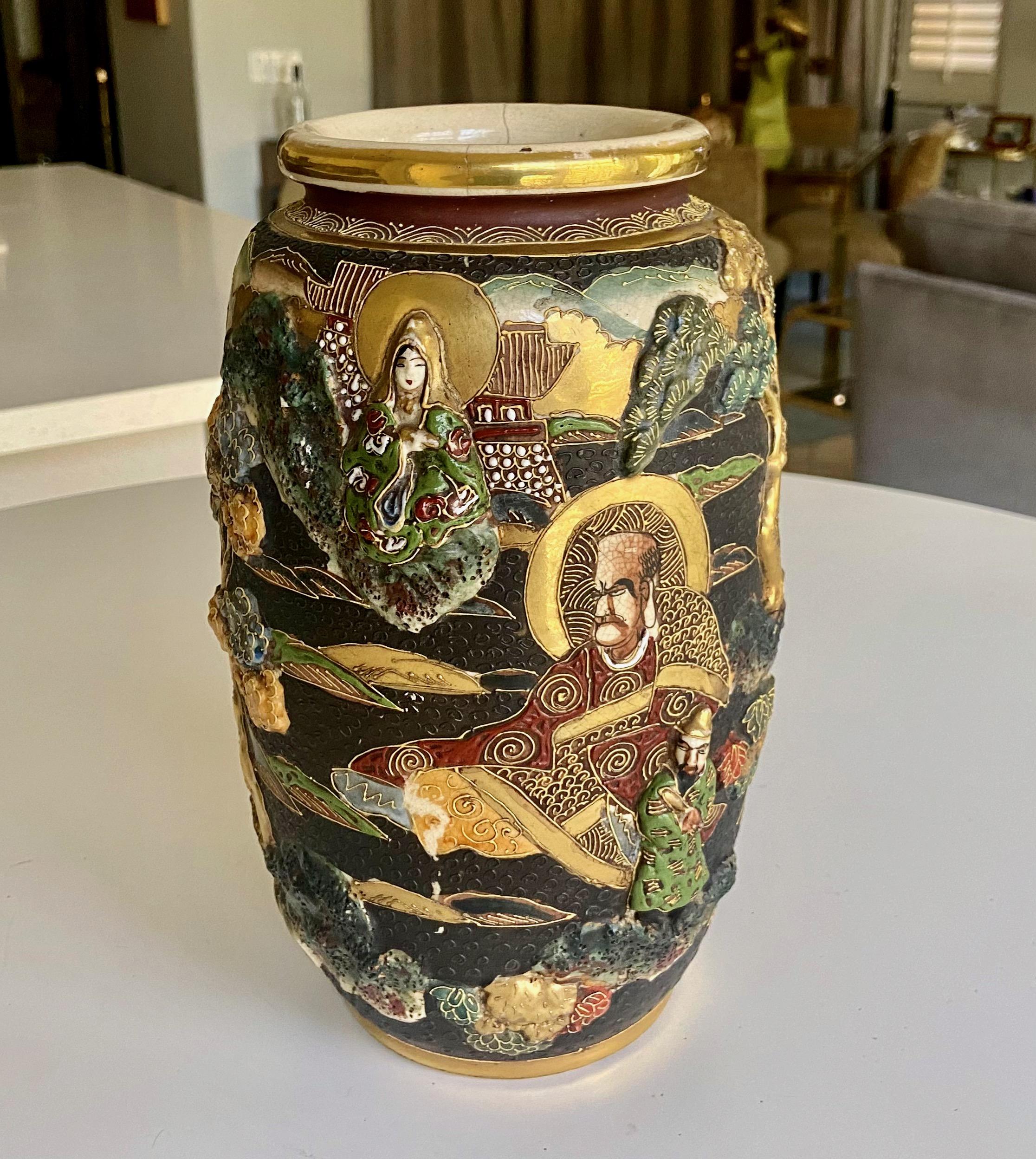 Antique 20th century Japanese hand painted ceramic pottery vase. Embellished with gold gilt accents and raised enamel figural and tree decorations. Signed. 