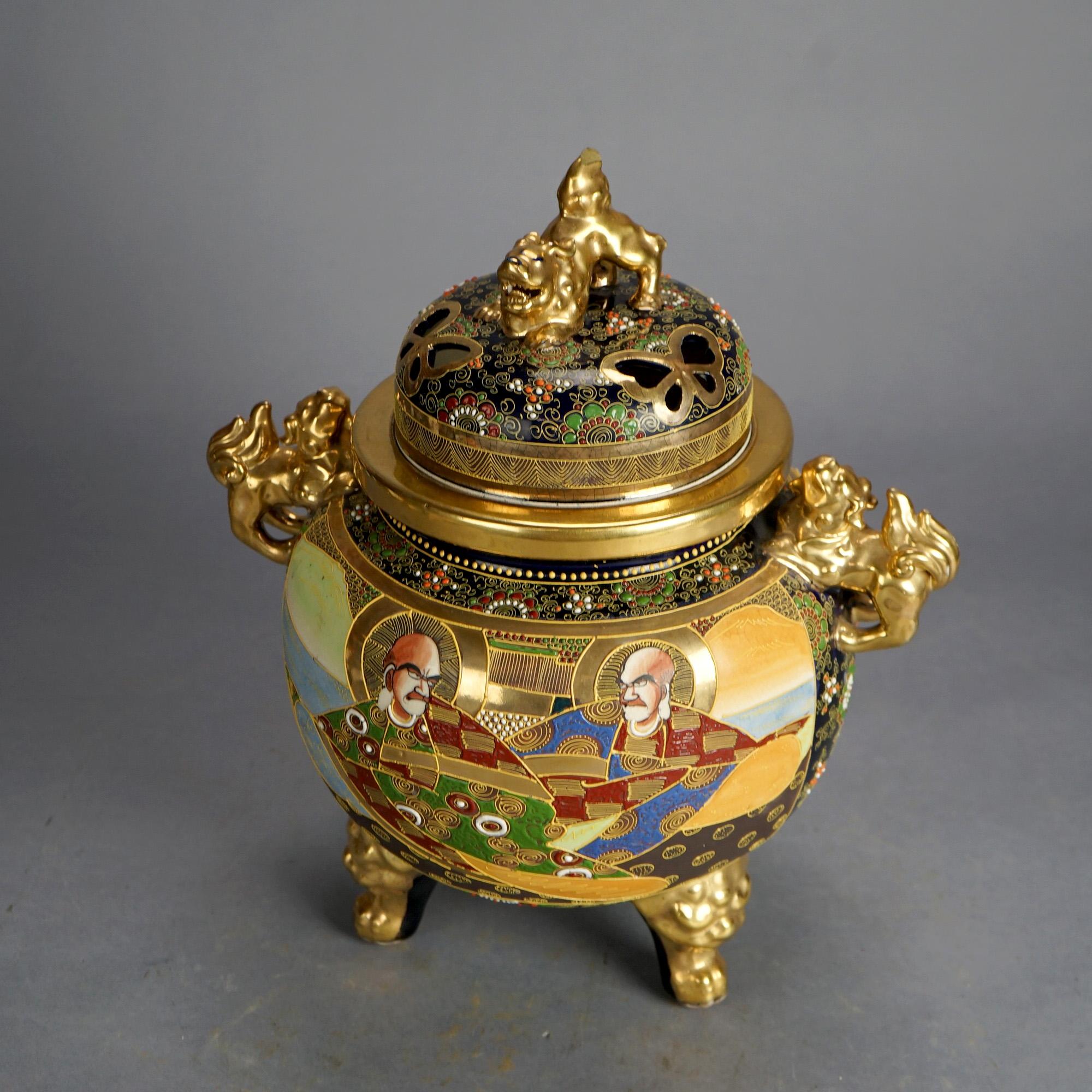 An antique Japanese Satsuma censer offers porcelain construction with hand painted figures, foo dogs throughout, heavily gilt highlights, and raised on three feet; signed on base as photographed; c1930

Measures- 15.75''H x 13.25''W x 10.5''D