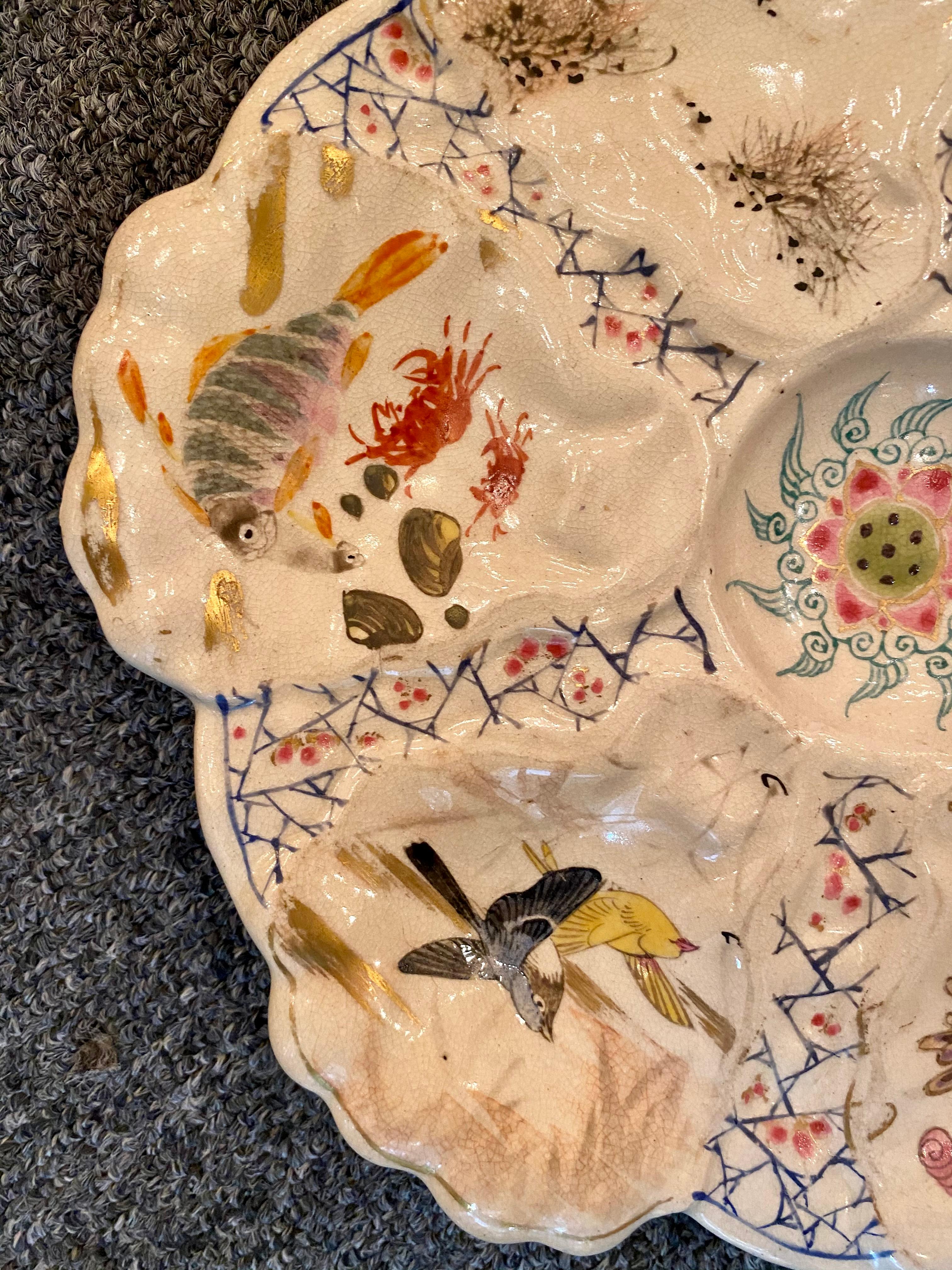 Antique Japanese hand-painted Satsuma porcelain oyster plate with various birds and sea life, circa 1890.