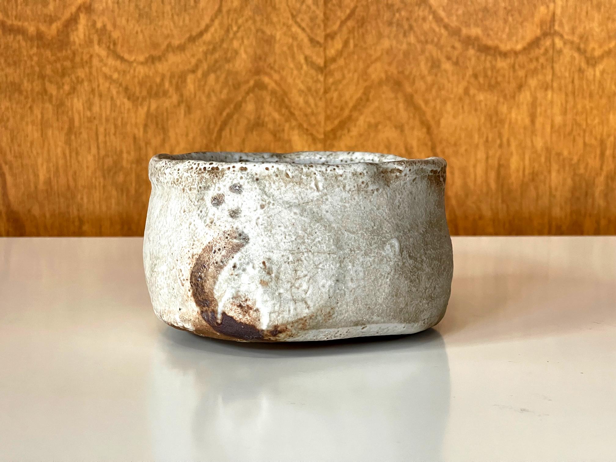 Nous vous proposons un bol à thé japonais en céramique (chawan) utilisé lors de la cérémonie traditionnelle du chado. La coupe a été empotée en forme de sabot avec un pied annulaire rasé extrêmement bas. Sa taille et ses proportions harmonieuses