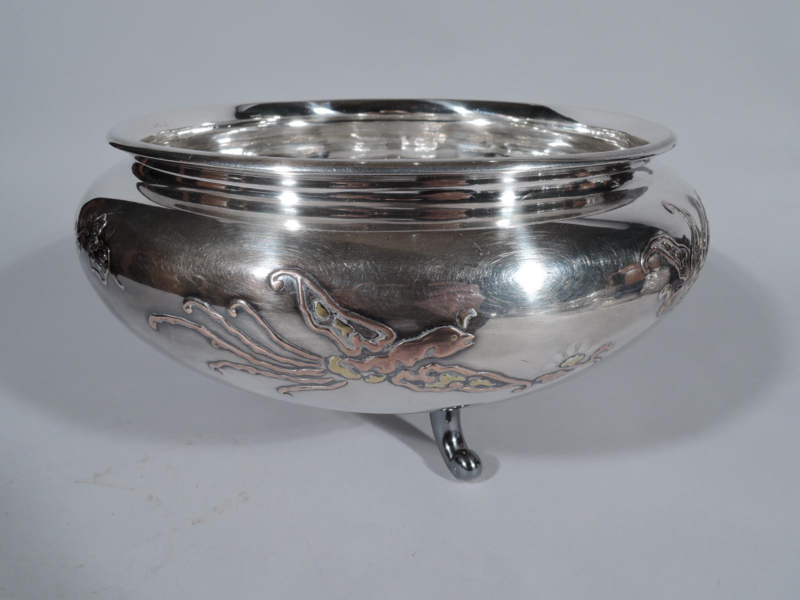 Japanese silver bowl, circa 1890. Bellied with applied gold, copper, and silver flowers and birds. Ornament fluid and stylized. Three C-scroll supports with shaped and tooled cloud mounts. Marked. Heavy weight: 42.5 troy ounces.