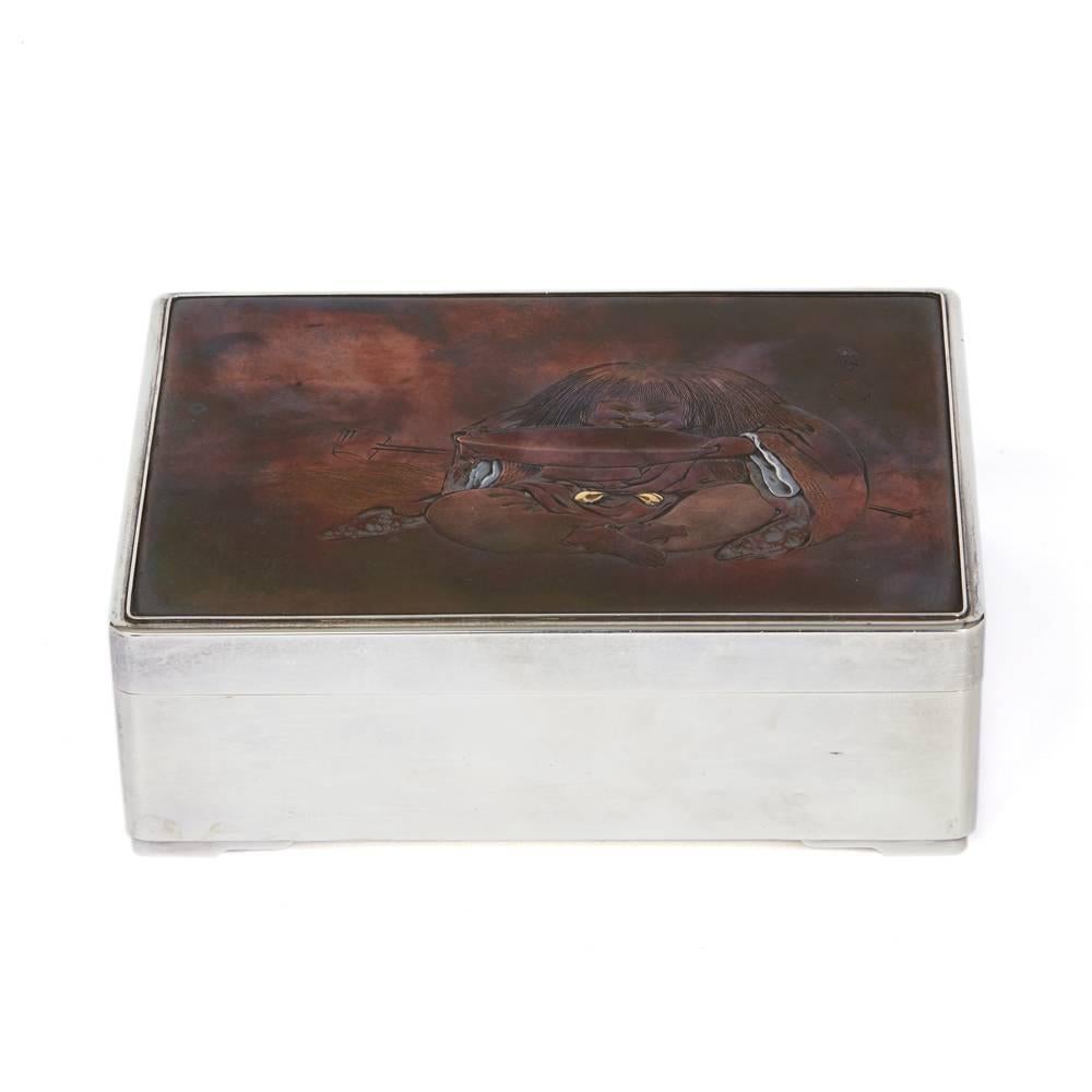 An extremely fine quality antique heavy gauge Japanese silver incense box, the cover inset with a copper and inlaid metal panel depicting a seated figure drinking from a large bowl and the panel is signed to the upper right corner. The rectangular