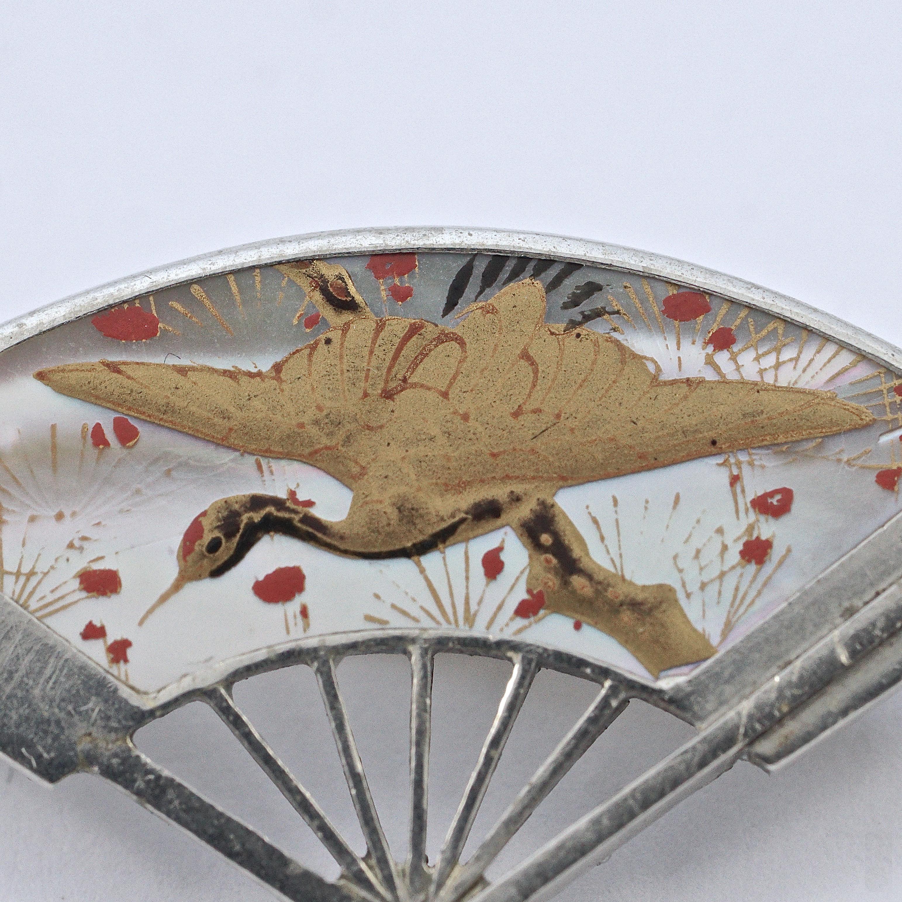 
Antique Japanese silver plated fan brooch featuring an exquisite hand painted red and gold crane and flowers design on mother of pearl. Measuring length 3.6cm / 1.4 inches by width 2.25cm / .88 inch. There is a stamp to the reverse. The pin has