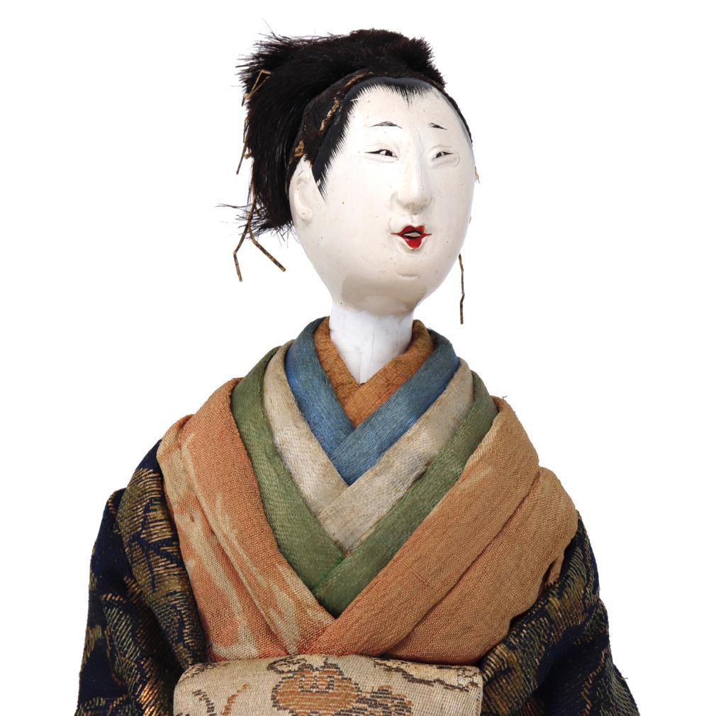 Antique Japanese Takeda ningyo of an Oiran or a kabuki actor in the role of a legendary high ranking courtesan, a standing figure costumed in layered kimono, descending on her sloping shoulders with the outer robe a kinran brocade of a large leaf