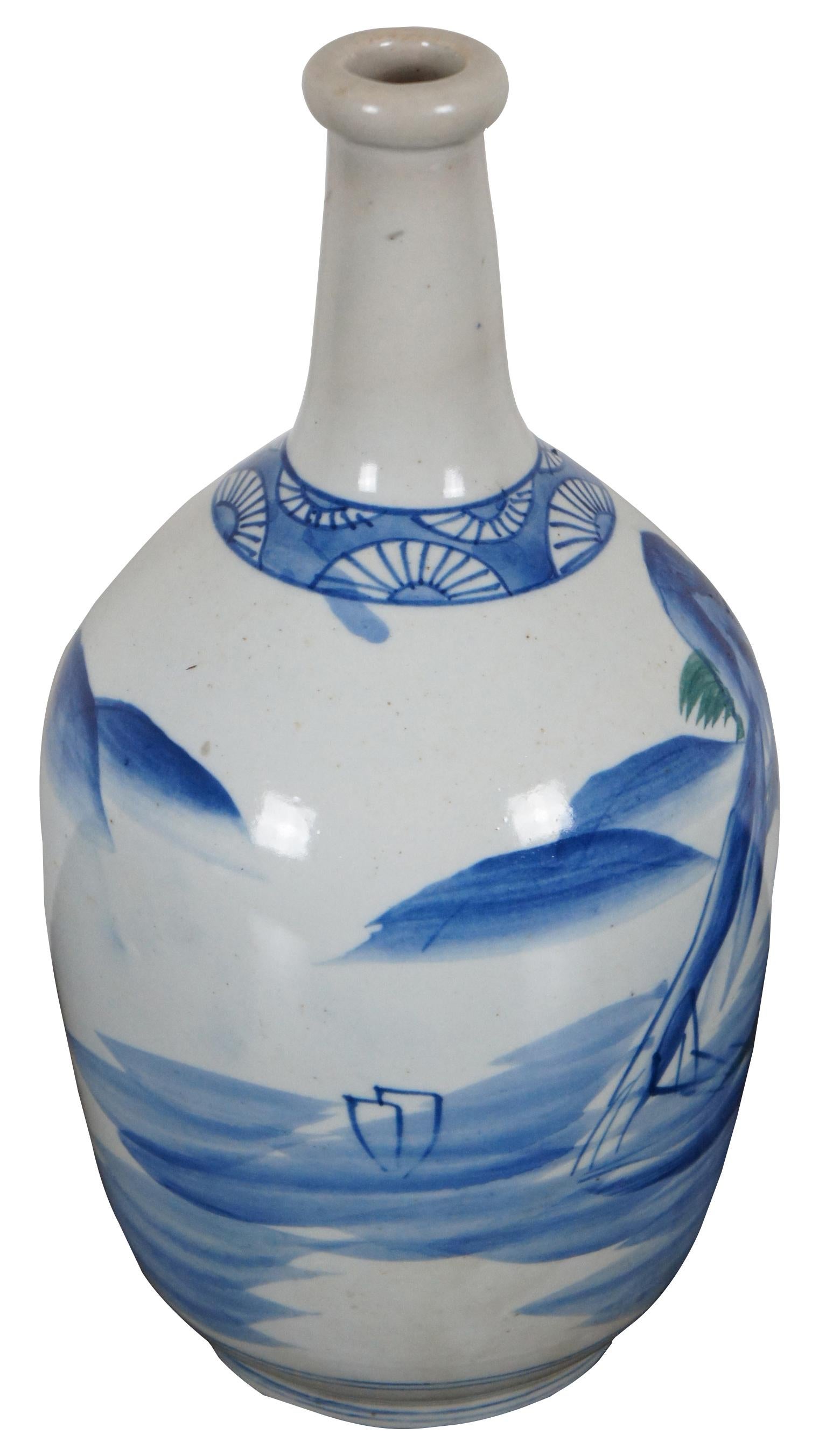 Antique Japanese ceramic tokkuri or sake bottle with a blue painted landscape.
  
