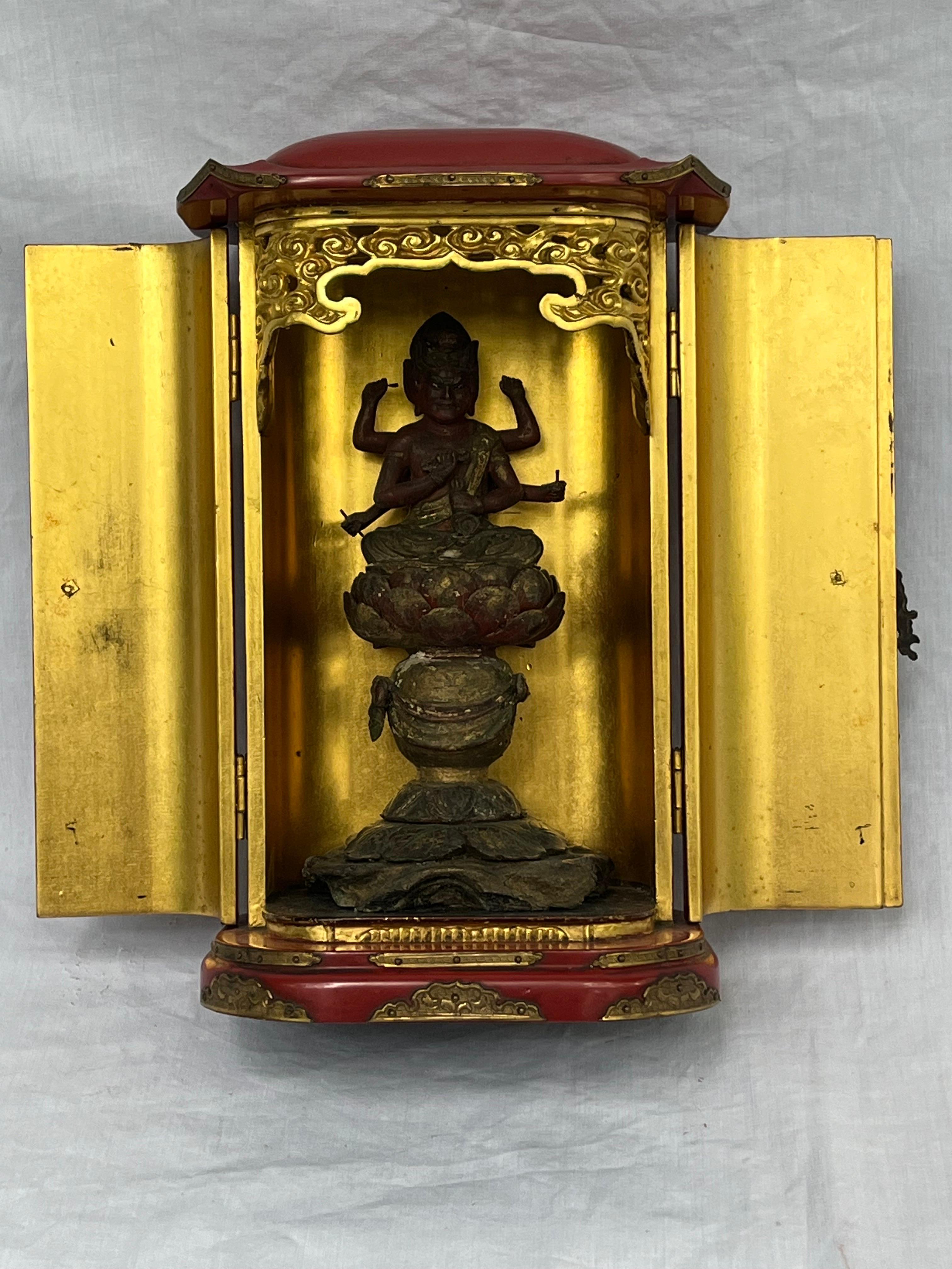 An antique Japanese traveling altar of Aizen Myoo or Ragaraja. I believe the object to be older than the 'early 20th century' guess I offered, but I'm really not sure. The carved deity sits inside the red lacquered altar, doors easily open and