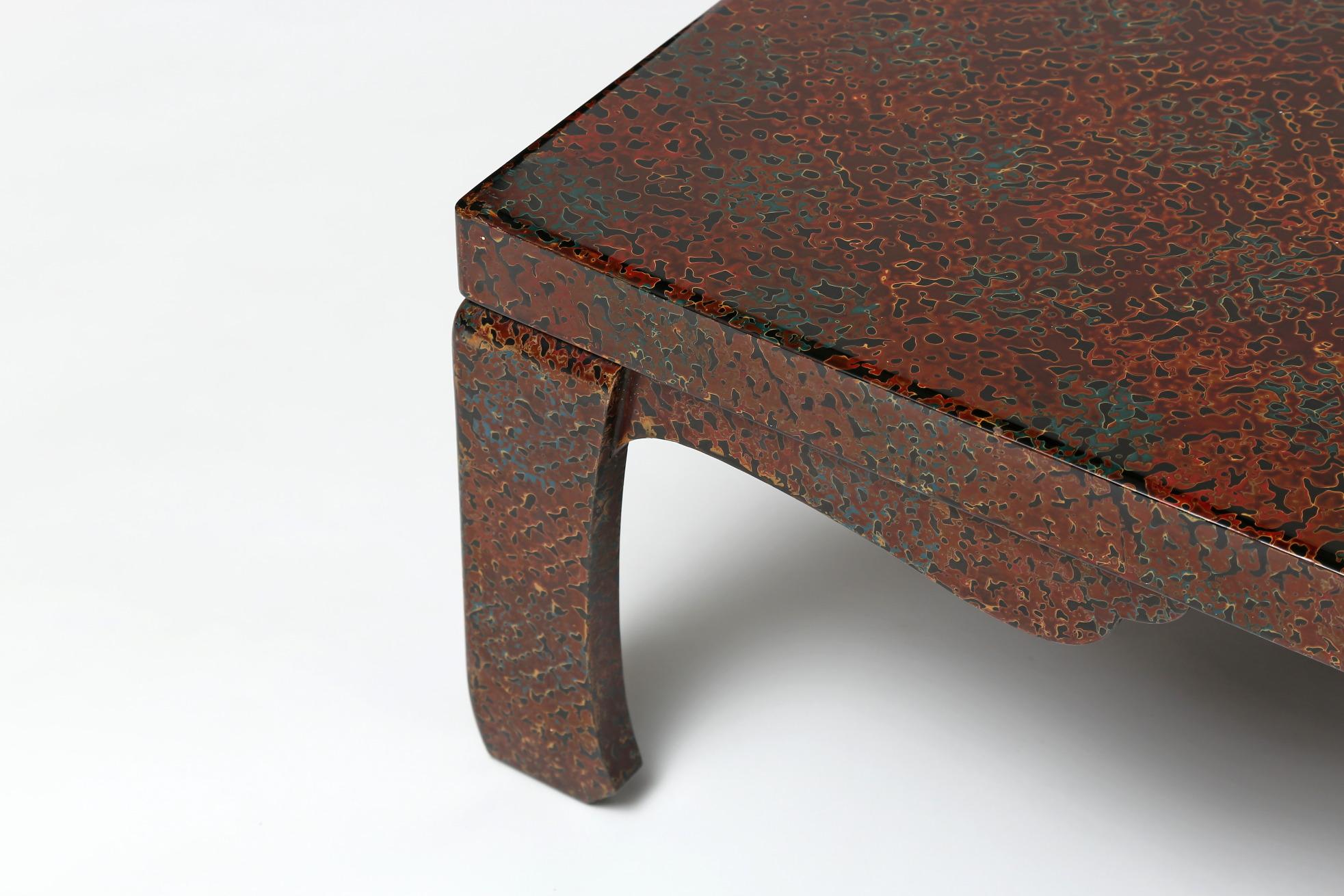 The wonderful low table with a solid plank top, supported on slightly curved corner legs with shaped spandrels, covered in special lacquer with the technique known as tsugaru where many layers of different coloured lacquers are applied, in drips and