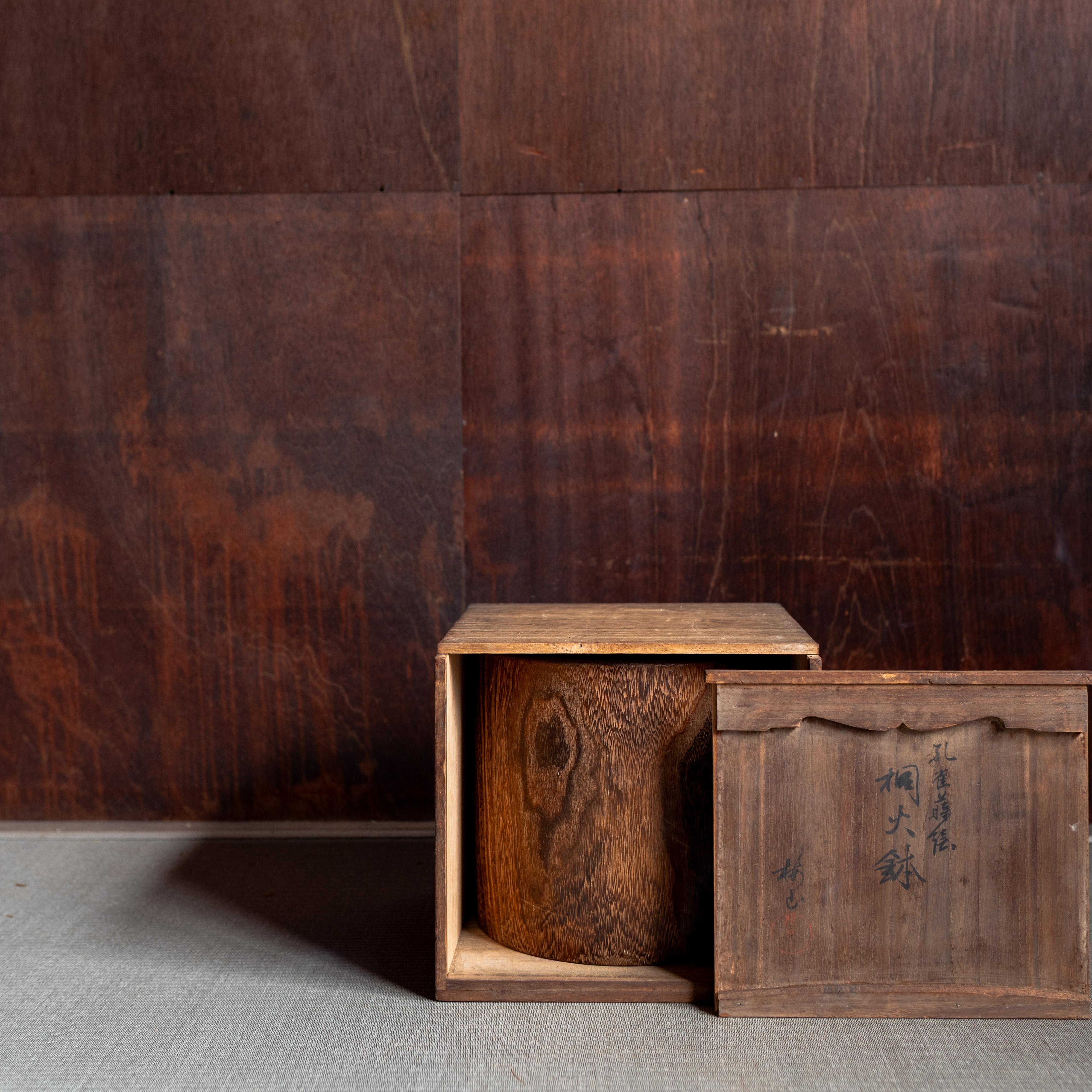 Un bellissimo hibachi giapponese antico realizzato in legno ricco di venature, con un elegante disegno intarsiato di una piuma di pavone. Tradizionalmente, gli hibachi venivano utilizzati come bracieri a carbone portatili per riscaldare le stanze,