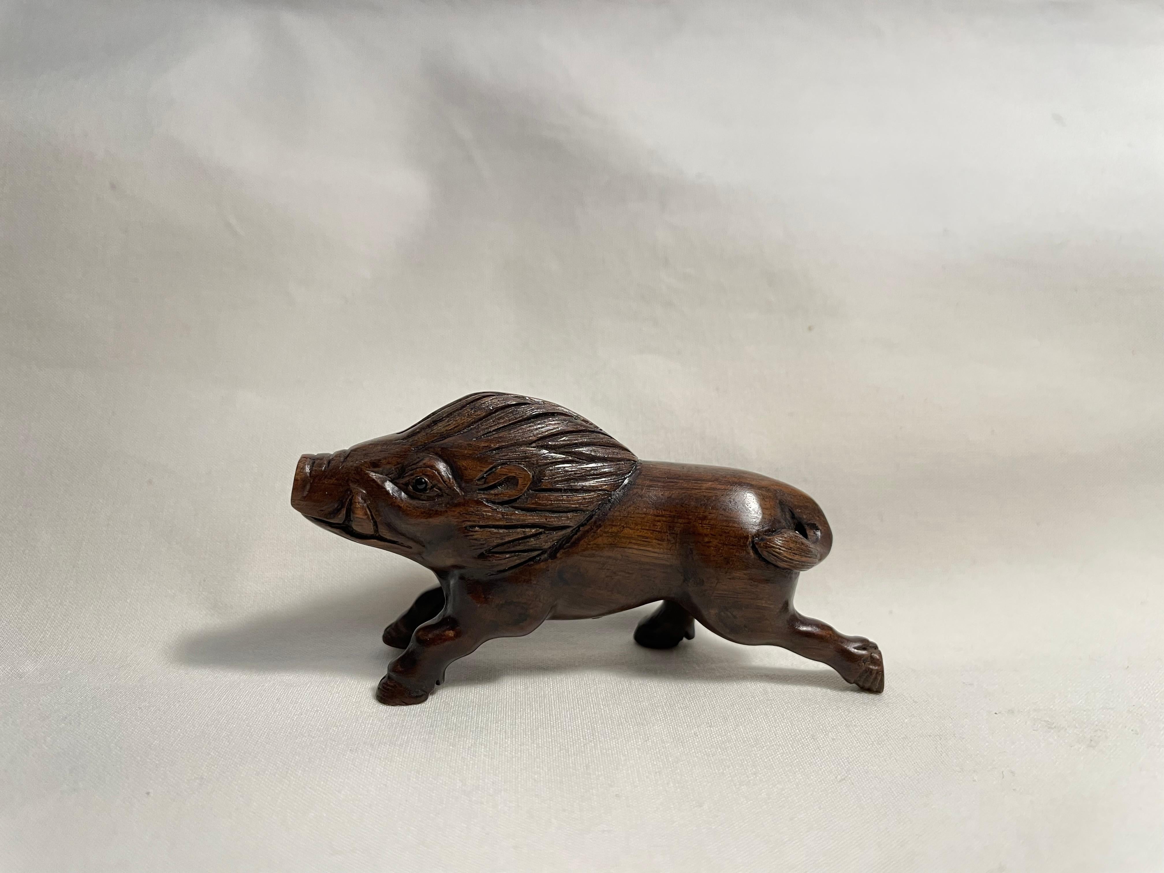 This is an antique netsuke made in Japan around Showa period 1960s.

Dimensions: 2.5 x 6.8 x H3.7 cm
Sculpture: Wild Boar
Era: 1960s (Showa) 

Netsuke is a miniature sculpture, originating in 17th century Japan.
Initially a simply-carved button