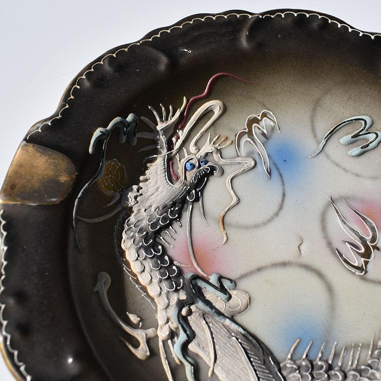 Precioso cenicero o baratija de porcelana artesanal hecha a mano. Este bonito neceser presenta un diseño de dragón moriage. Creado con engobe y aplicado alrededor del cuerpo del cuenco, el llamativo dragón está pintado a mano en un precioso azul,