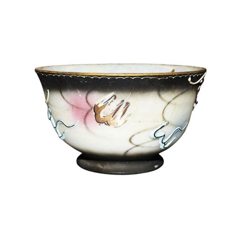 A beautiful artisanal handcrafted porcelain Dragon ware teacup. This set features a moriage dragon design. Created from slip and applied around the body of the cup, the eye-catching dragon is hand-painted in a gorgeous blue, back, and gray with