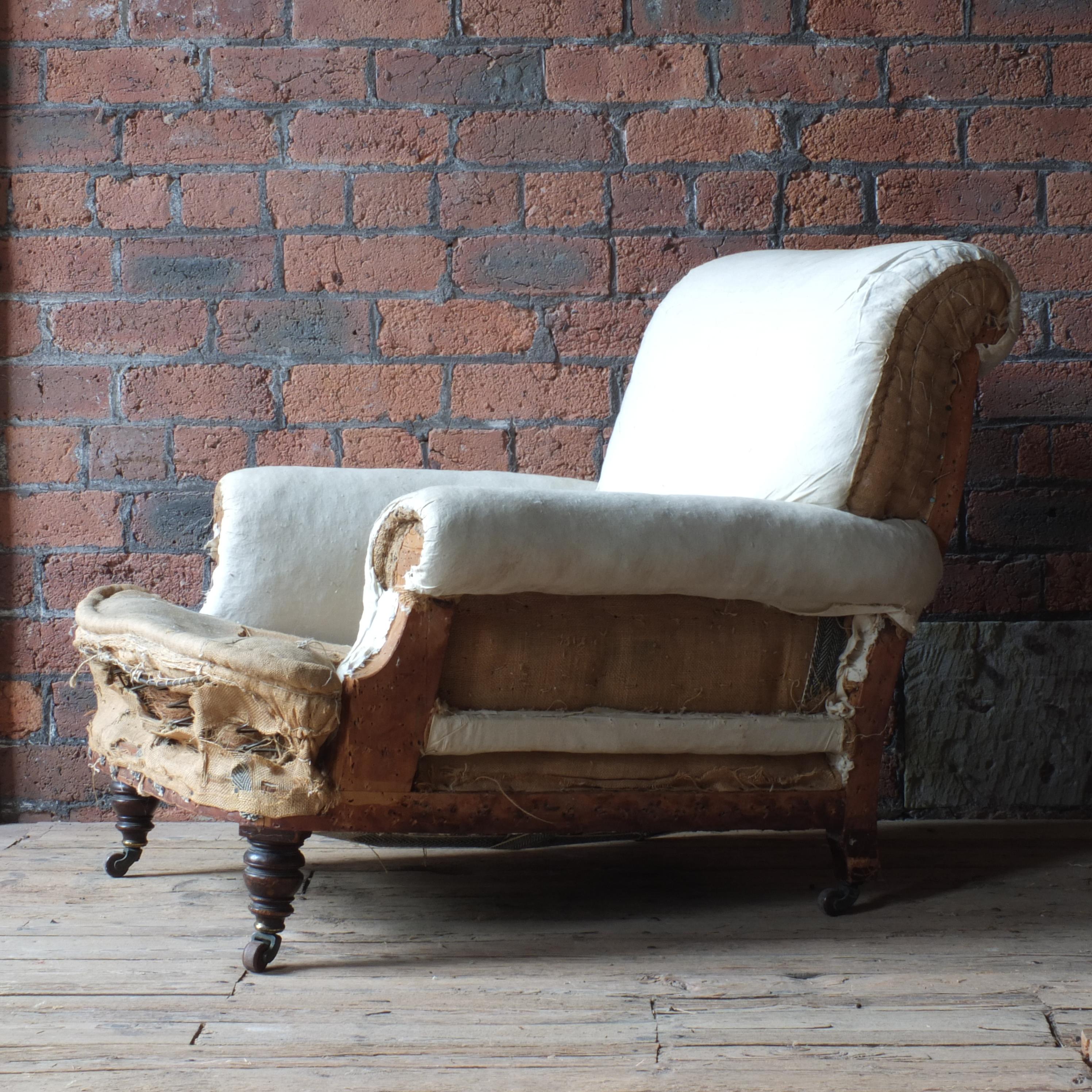 A large deep seated country house armchair by Jas Shoolbred - London c1880. Raised on mahogany turned front legs with the original stamped brass and ceramic casters.

The chair is in structurally sound condition and only requires upholstery If you