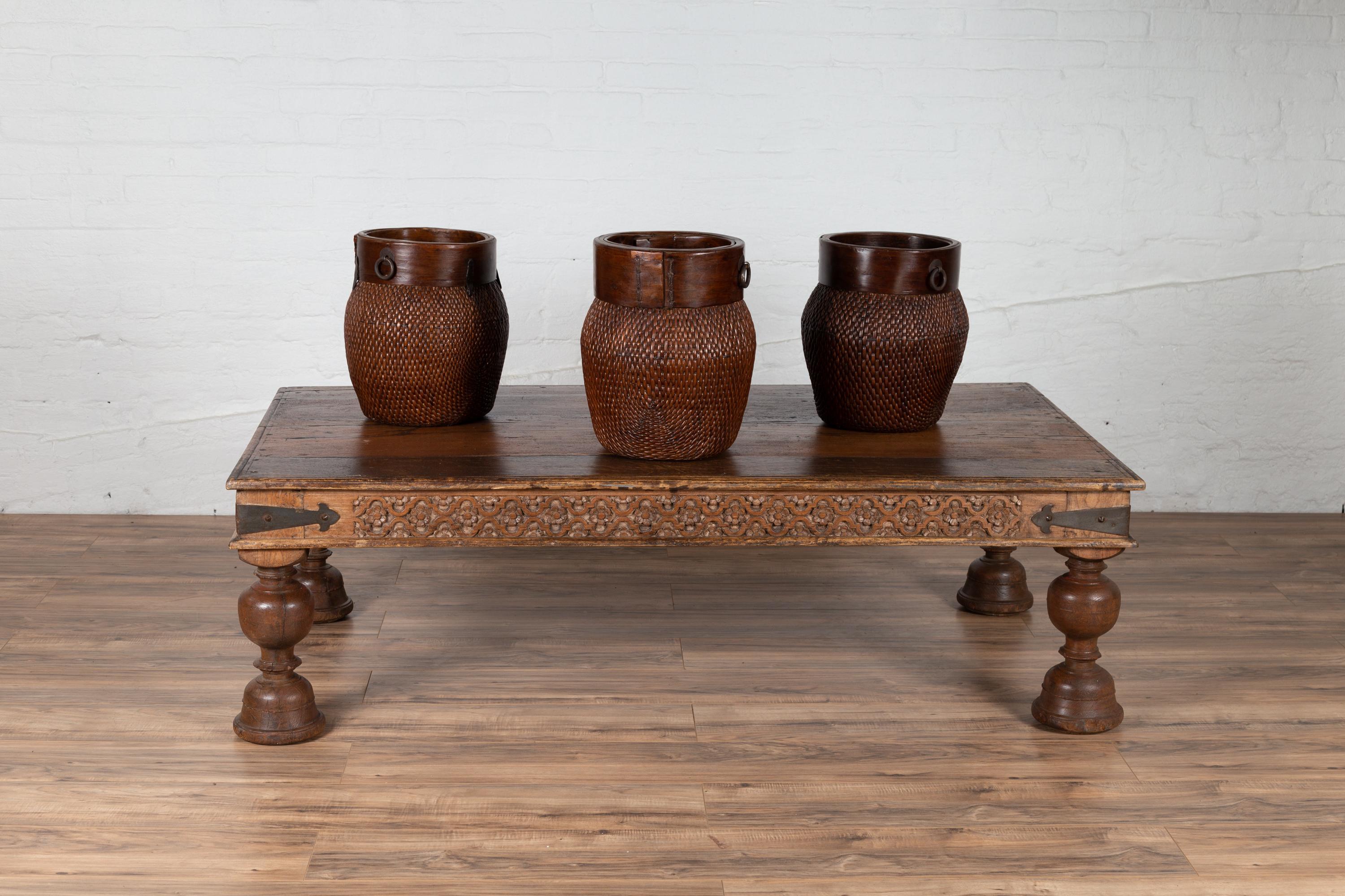 An antique Javanese teak wood long coffee table from the early 20th century, with hand carved apron and globe-inspired turned legs. Born on the island of Java, this exquisite coffee table features a rectangular top with nicely weathered patina,