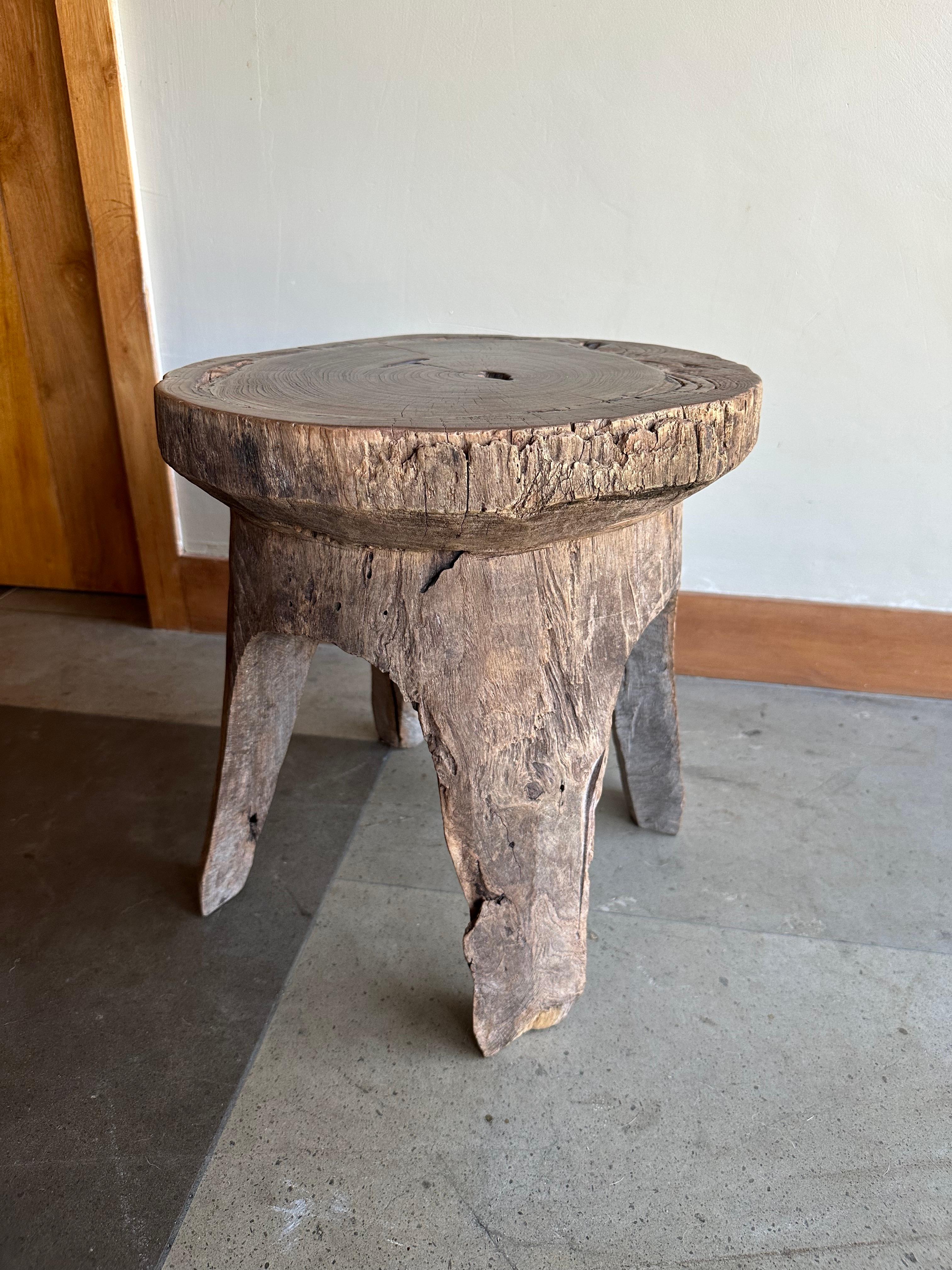 A wonderfully vibrant antique teak stool from Java, Indonesia. This stool was carved from a single block of wood and features a wonderful mix of wood textures and shades. The age-related patina adds to its charm. The perfect object to bring warmth