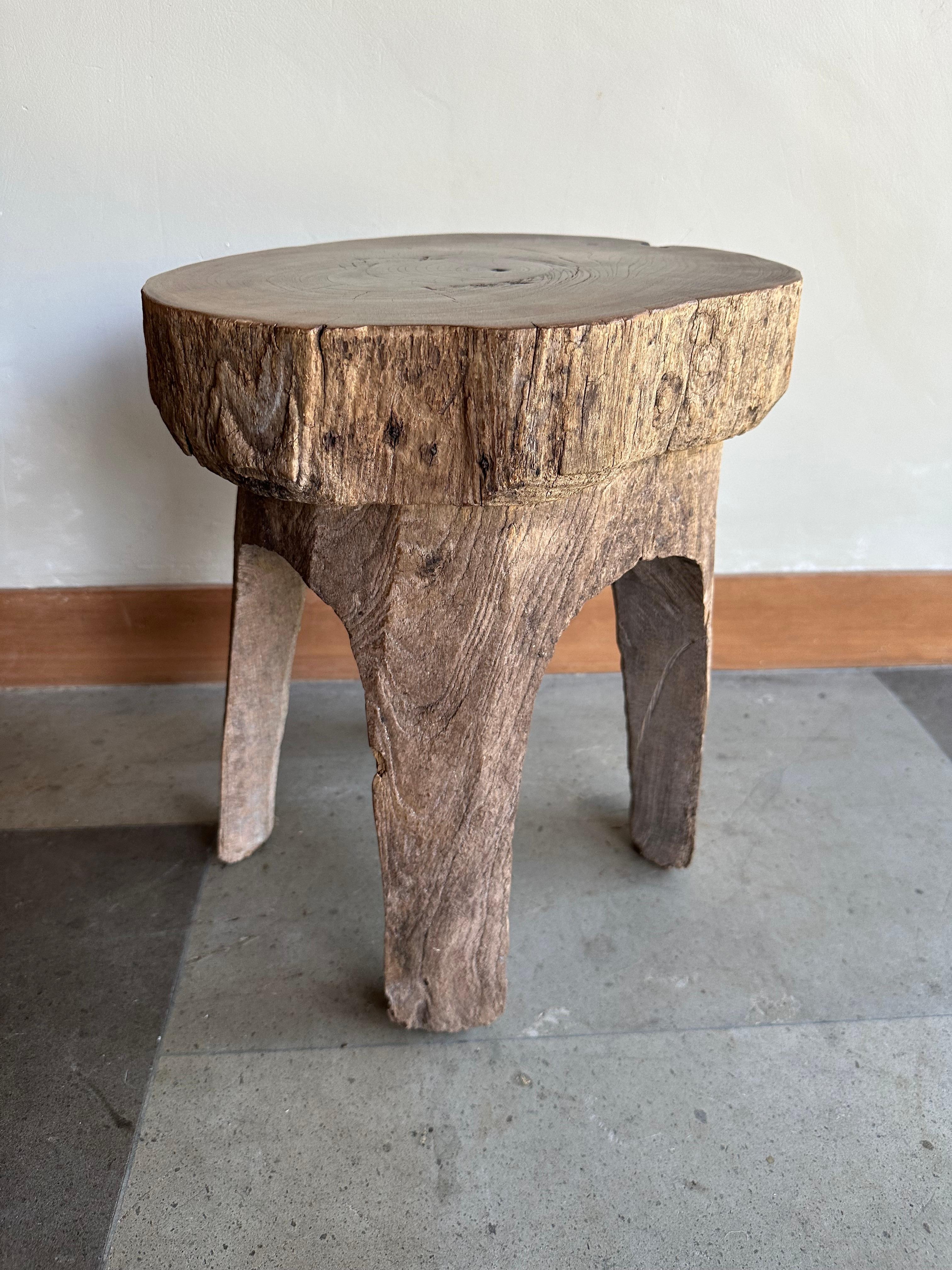 A wonderfully vibrant antique teak stool from Java, Indonesia. This stool was carved from a single block of wood and features a wonderful mix of wood textures and shades. The age-related patina adds to its charm. The perfect object to bring warmth
