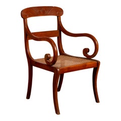 Antique Javanese Wooden Armchair with Carved Back, Curving Arms and Rattan Seat