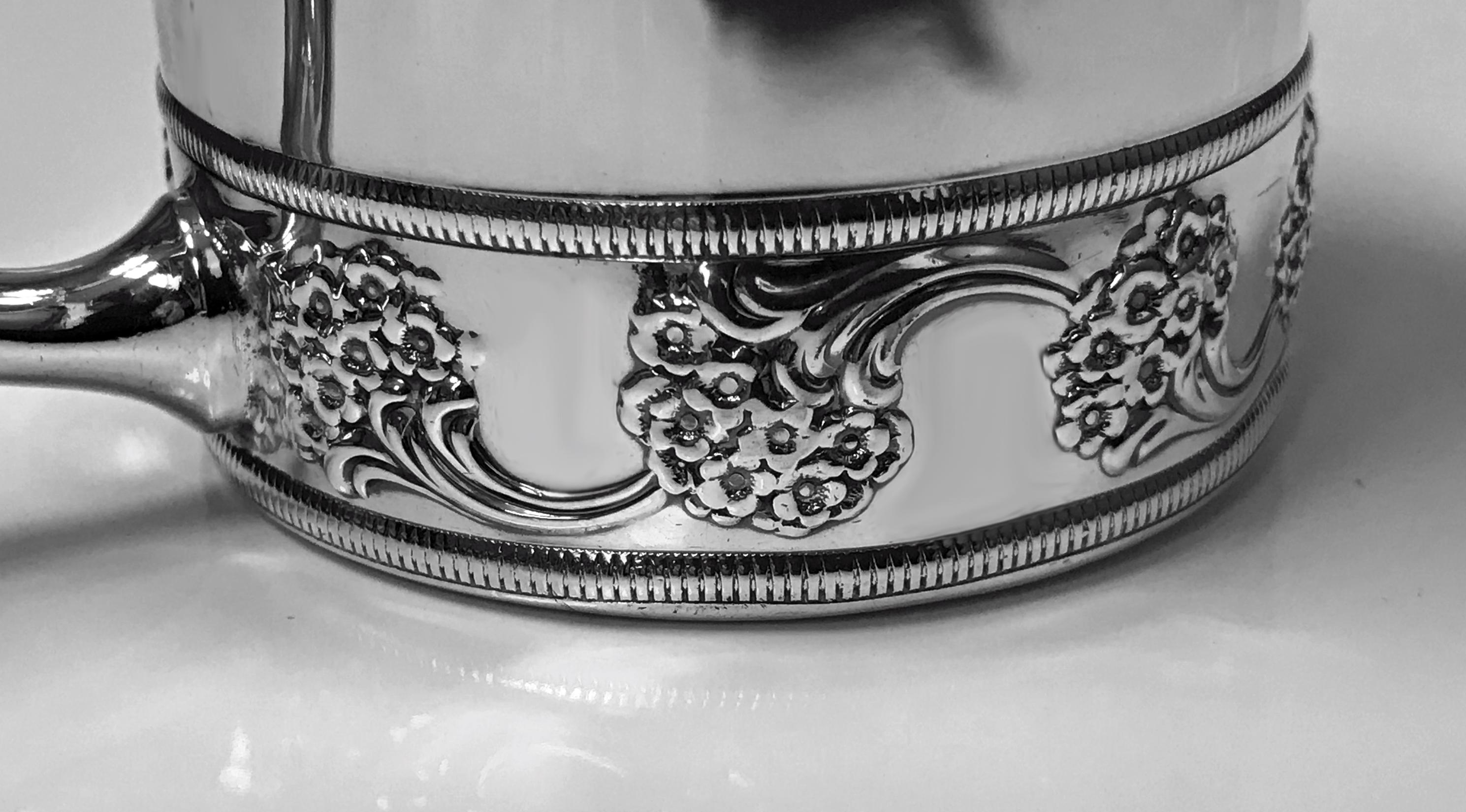 Antique J.E.Caldwell sterling silver cup, circa 1900. Slightly tapered cylindrical body, lower border of embossed scrolling branch leaf design, plain handle. Stamped under base Sterling J.E.Caldwell & Co design number 7846. Weight: 130 grams. 4.17
