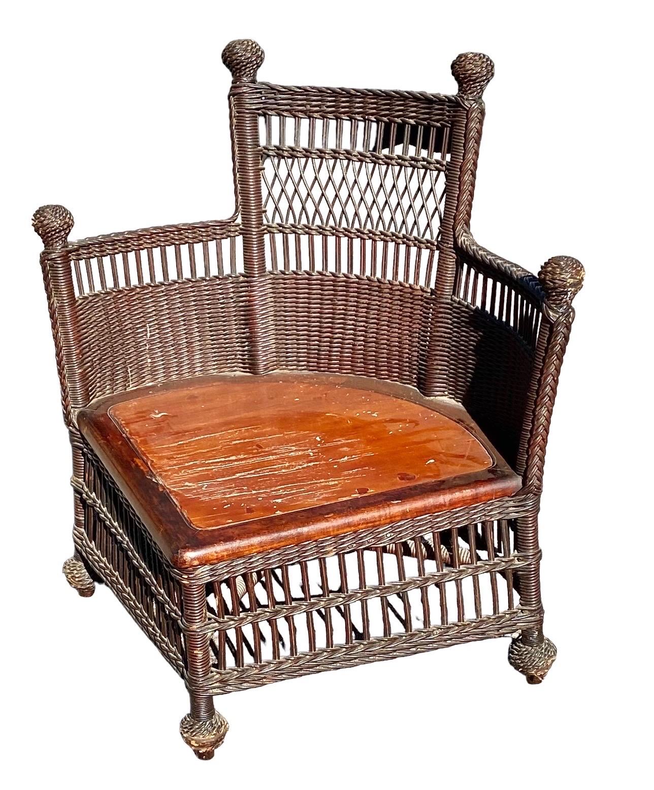 A charming antique late American Victorian wicker corner chair attributed to Jenkins and Phipps of Wakefield, Mass, having the original wood seat deck for a cushion. 

A practical piece to fit into that empty corner of your sunroom, garden room,