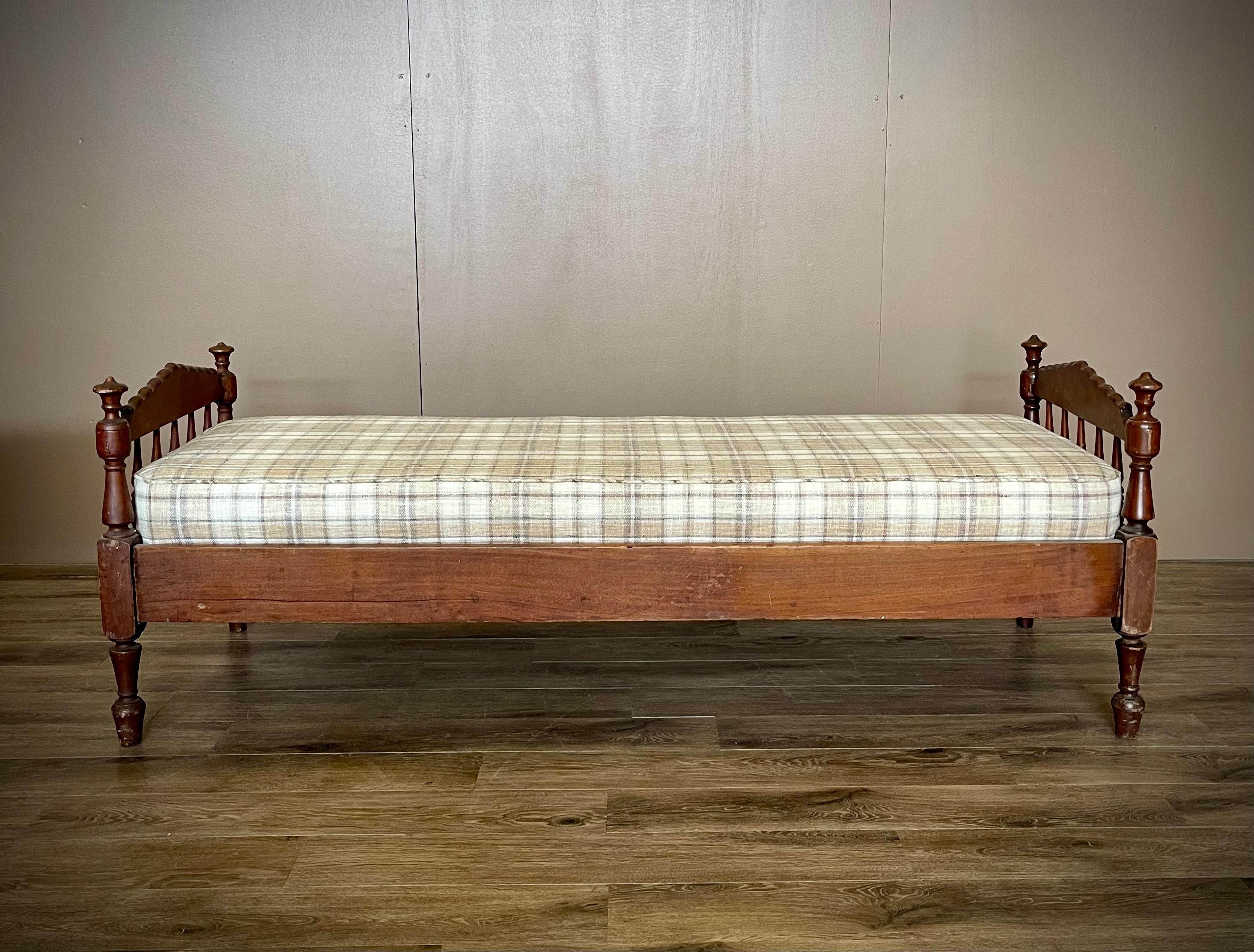 Upgrade your relaxation with our charming 19th century Jenny Lind daybed featuring a freshly upholstered neutral plaid cushion. Perfect for lounging, its timeless design adds a touch of elegance to any space while ensuring comfort and versatility.