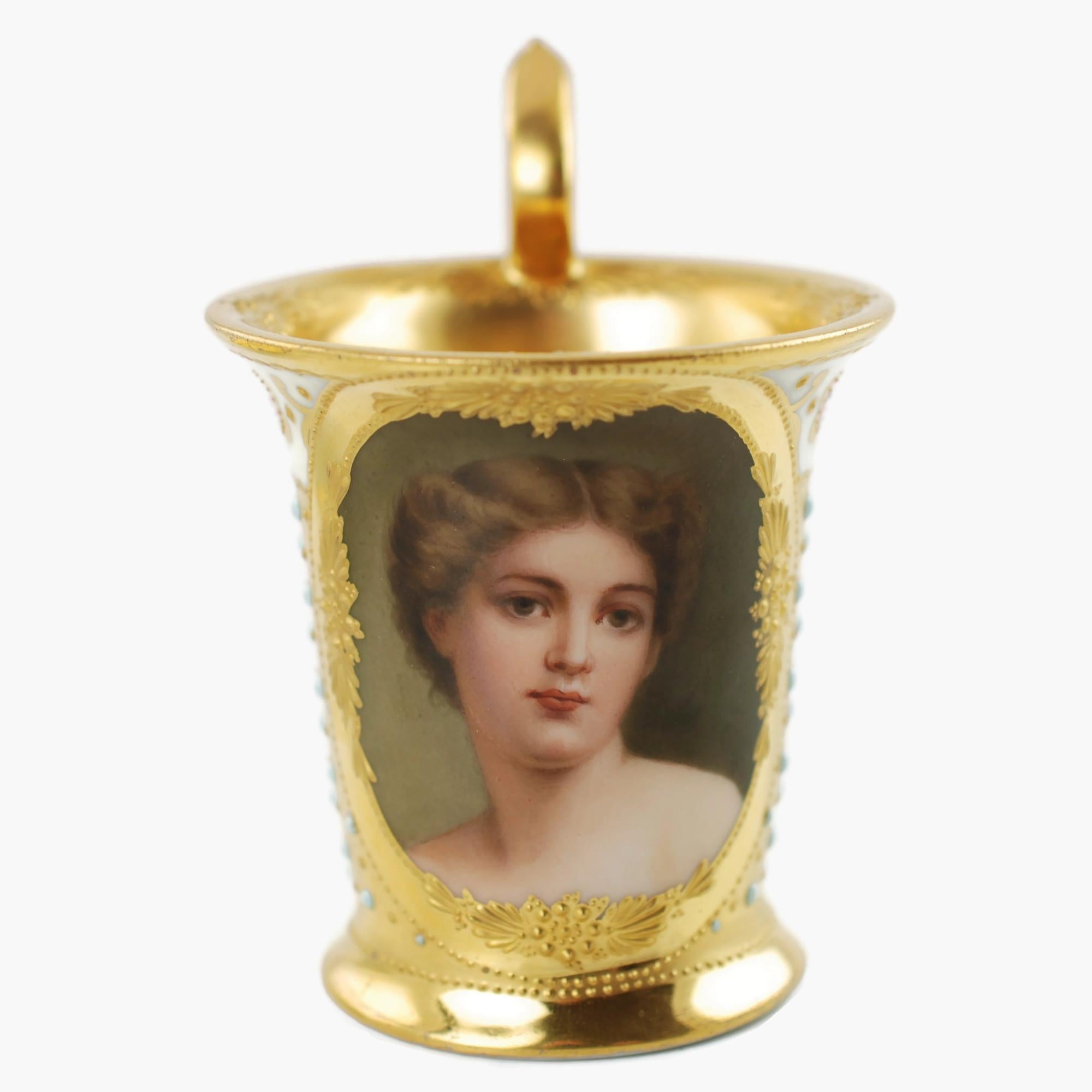 This late 19th century jeweled gilt encrusted Dresden porcelain chocolate cup and saucer set feature the portrait of a young woman. The beautifully executed portrait is located at the center of an oval reserve framed by raised gilt beads and raised