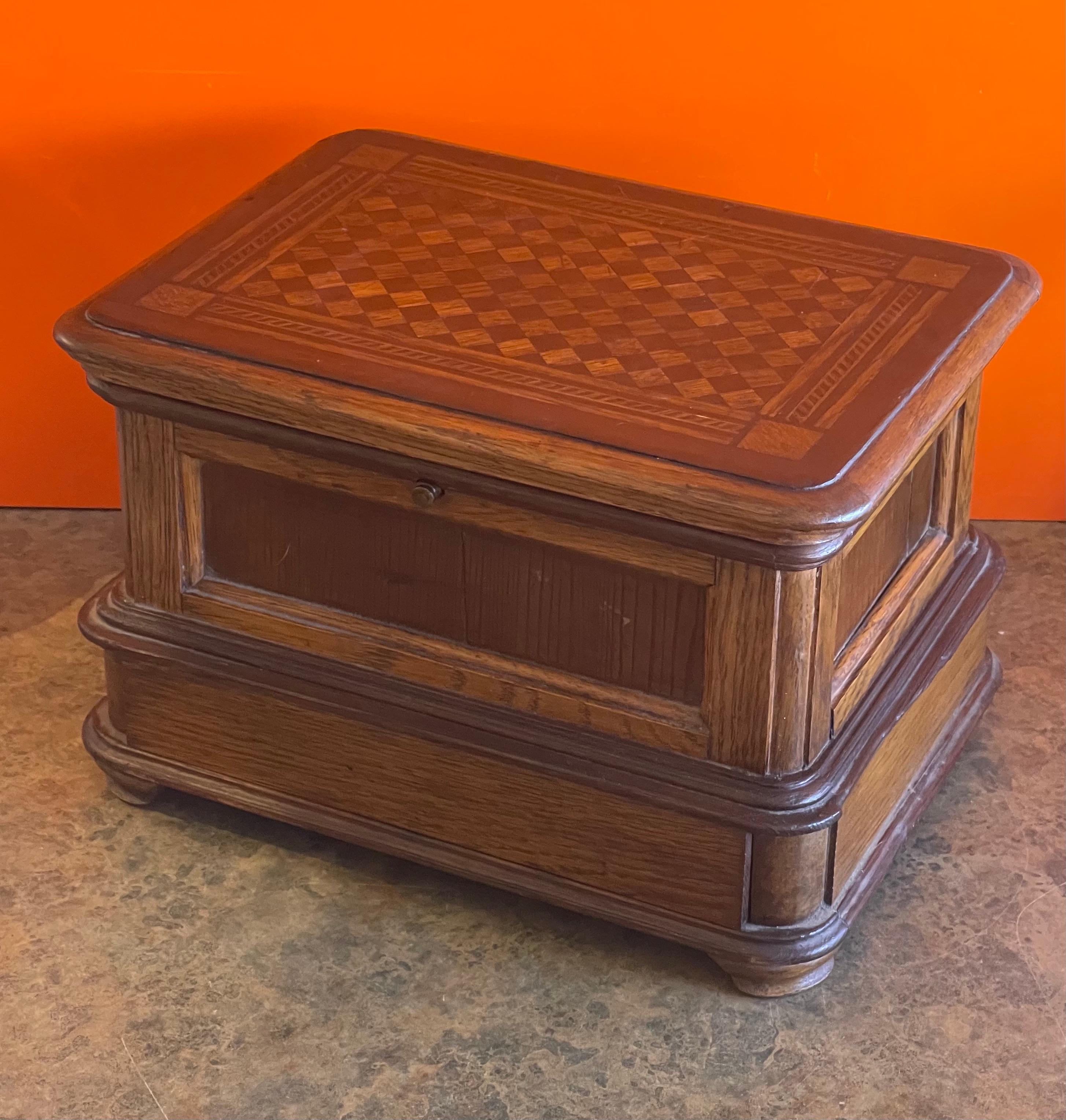 Simple and elegant antique jewelry box with inlaid wood top, circa 1930s. The piece is more of a decorative item than functional; the top opens up, but the button can stick at times. The mirror inside is missing and the bottom 