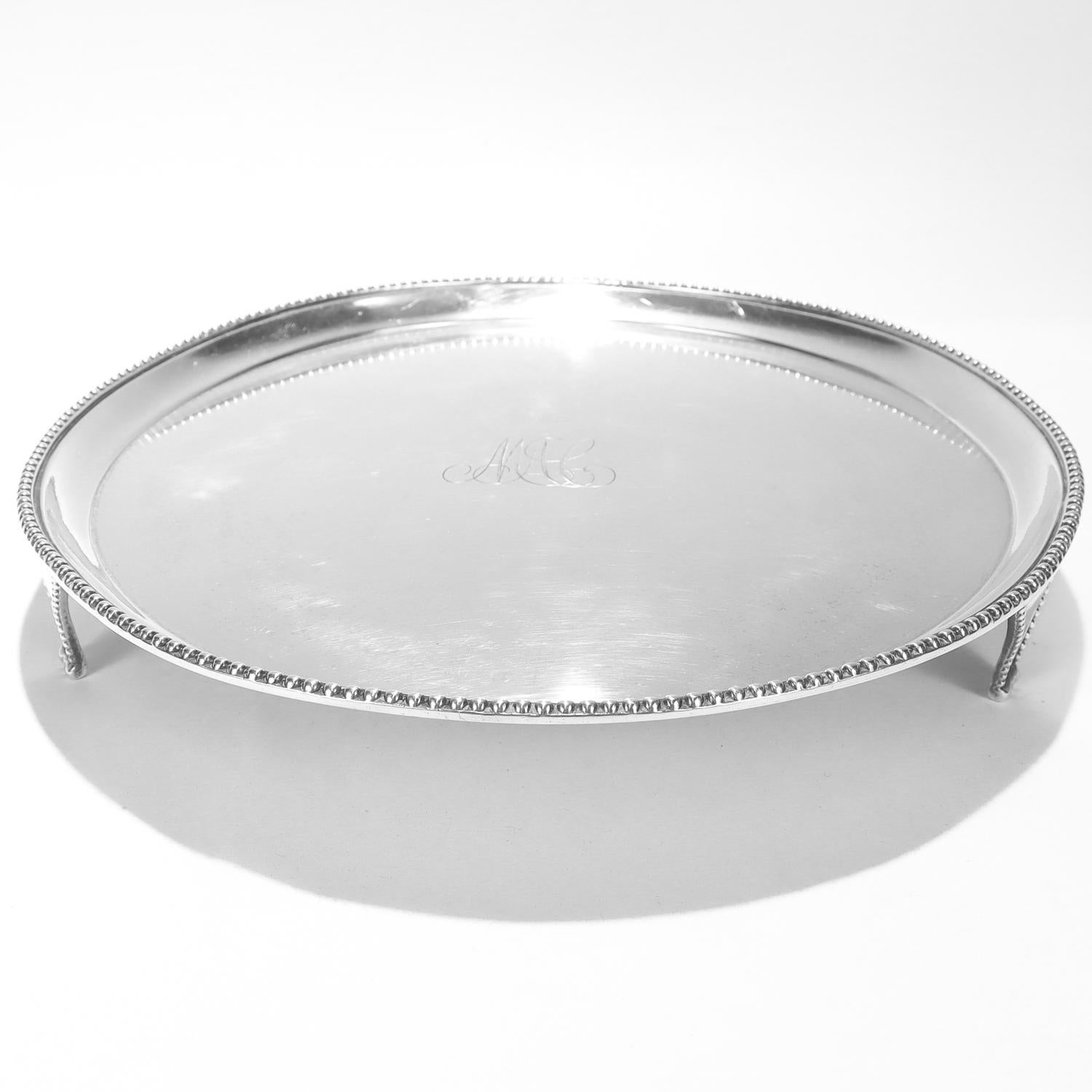 Un raffinato salver americano firmato.

In argento con moneta.

I.T. marcati

Attribuito a John Targee di New York.

Ha la forma di un grande piatto dal bordo spesso e perlinato, sostenuto da tre piedi affusolati e perlinati.

Monogram al centro con